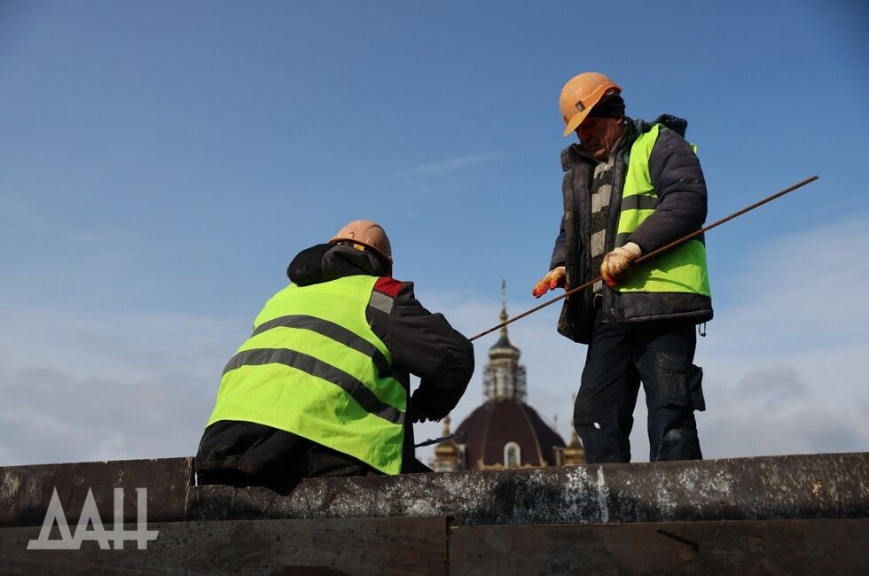 ФОТО: Хроники возрождения  В драматическом театре Мариуполя продолжается работа по восстановлению здания. По планам, достройка должна завершиться к концу 2025 года. На сегодняшний день выполнено 65% от общего объема работ.  Представитель подрядной организации сообщил о текущих этапах монтажа. Ведется установка металлоконструкций и монтаж кровли. Бетонные работы также продолжаются — сейчас строится третий этаж балкона, который будет служить зрительным залом. Бельэтаж уже готов, а работы по первому балкону завершены. В данный момент начинаются работы над вторым балконом, который будет трехъярусным.  Параллельно с этим идут работы по внутренней отделке. Стены нового здания уже начали штукатурить.   Процесс возрождения театра вызывает интерес у местных жителей, многие из которых помнят прежнее состояние здания.