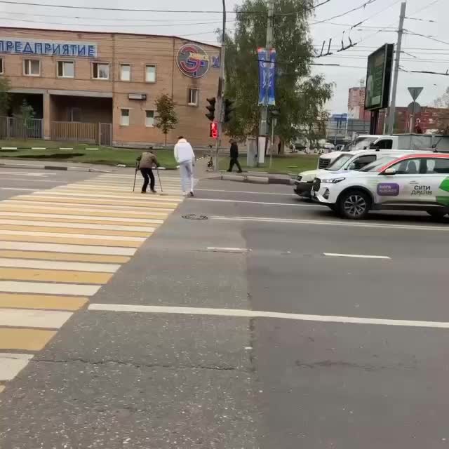 Парень проводит дедушку через проспект в Химках, водители проявляют уважение