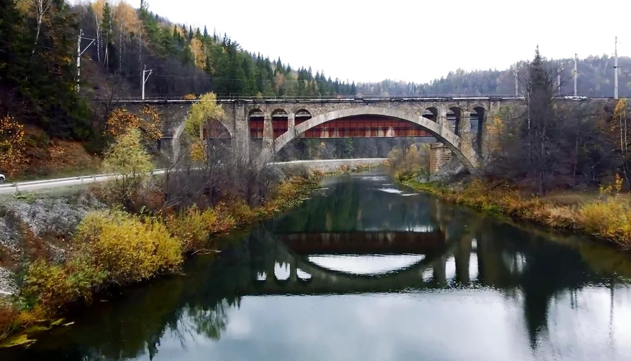 Никольский мост через реку Сим в Челябинской области взяли под охрану государства Сооружение признали объектом культурного наследия и включили в госреестр Построили мост в шести километрах от Миньяра в 1929 1930 годах Он состоит из четырех арок и облицован диким бутовым камнем Были использованы передовые на тот момент технологии и материалы которые доставляли на лошадях в специальных корытах грабарках Строительство проходило в очень сложных условиях Чтобы проложить железнодорожную дорогу рабочие прорубили проходы в скалистом грунте Существует историческое свидетельство о том что руководитель работ женщина инженер встала под мост во время первого испытания под нагрузкой символизируя веру в надежность конструкции Это был поступок ставший легендарным в истории строительства сообщает Госкомитет охраны ОКН Челябинской области На арке моста запечатлены дата окончания постройки и символы советской эпохи серп и молот Мост стал частью модернизации Самаро Златоустовской железной дороги которая соединила Поволжье Сибирь и европейскую часть страны По ней перевозили металл уголь и хлеб Никольский мост продолжает работать и считается важной достопримечательностью Челябинской области Фото скриншот с видео Подписывайтесь на Вести Южный Урал в MAХ