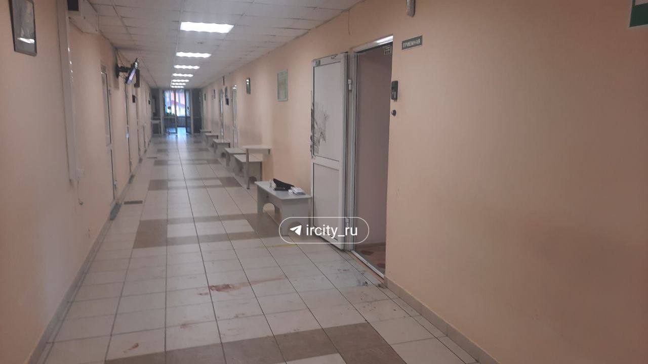 Вход на четвертый этаж, где произошло нападение, перегорожен лентой. В кабинете и приемной ещё работают следователи. В коридоре следы крови.
