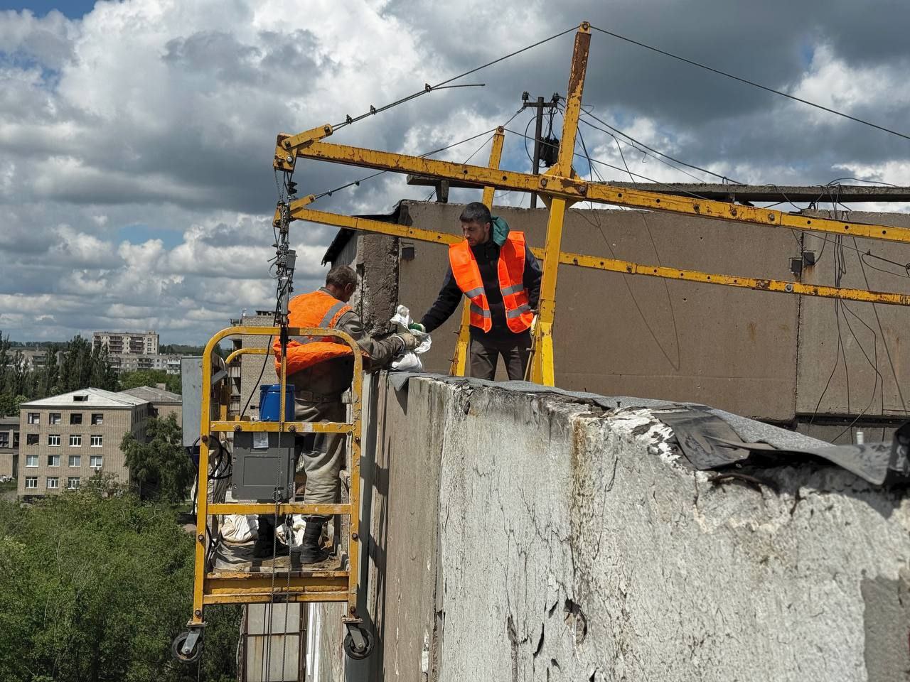 В рамках соглашения о сотрудничестве города Первомайска с Калужской областью в 2025 году восстановительные работы продолжаются на 29-ти объектах, из них: 18 многоквартирных жилых домов; два социальных объекта; два участка напорного канализационного коллектора; 6 объектов энергоснабжения; здание общежития. Реализуемый комплекс мероприятий по ремонту многоквартирных жилых домов затронул и дома номер 17, 19, и 19а по улице Куйбышева в городе Первомайске, которые за время военных действий пережили неоднократные обстрелы, повлекшие за собой значительное повреждение инфраструктуры. Это уже третий ремонт указанных домов. Строения нуждаются в выполнении различного спектра строительных работ, однако первоочередная задача – восстановление теплового контура. Ранее в этом доме силами калужских специалистов OSB-плитами были закрыты повреждённые окна пустующих квартир, затем остеклены места общего пользования - установлены на лестничных маршах новые пластиковые окна, отливы, откосы и двери пожарных выходов. На данный момент производится ремонт кровли домов. В ближайшее время специалисты приступят к установке в муниципальных квартирах новых пластиковых окон взамен поврежденным. Отмечу, что в приватизированных квартирах эта процедура производится самостоятельно собственниками за счет получения компенсационных выплат за повреждённое жилье.