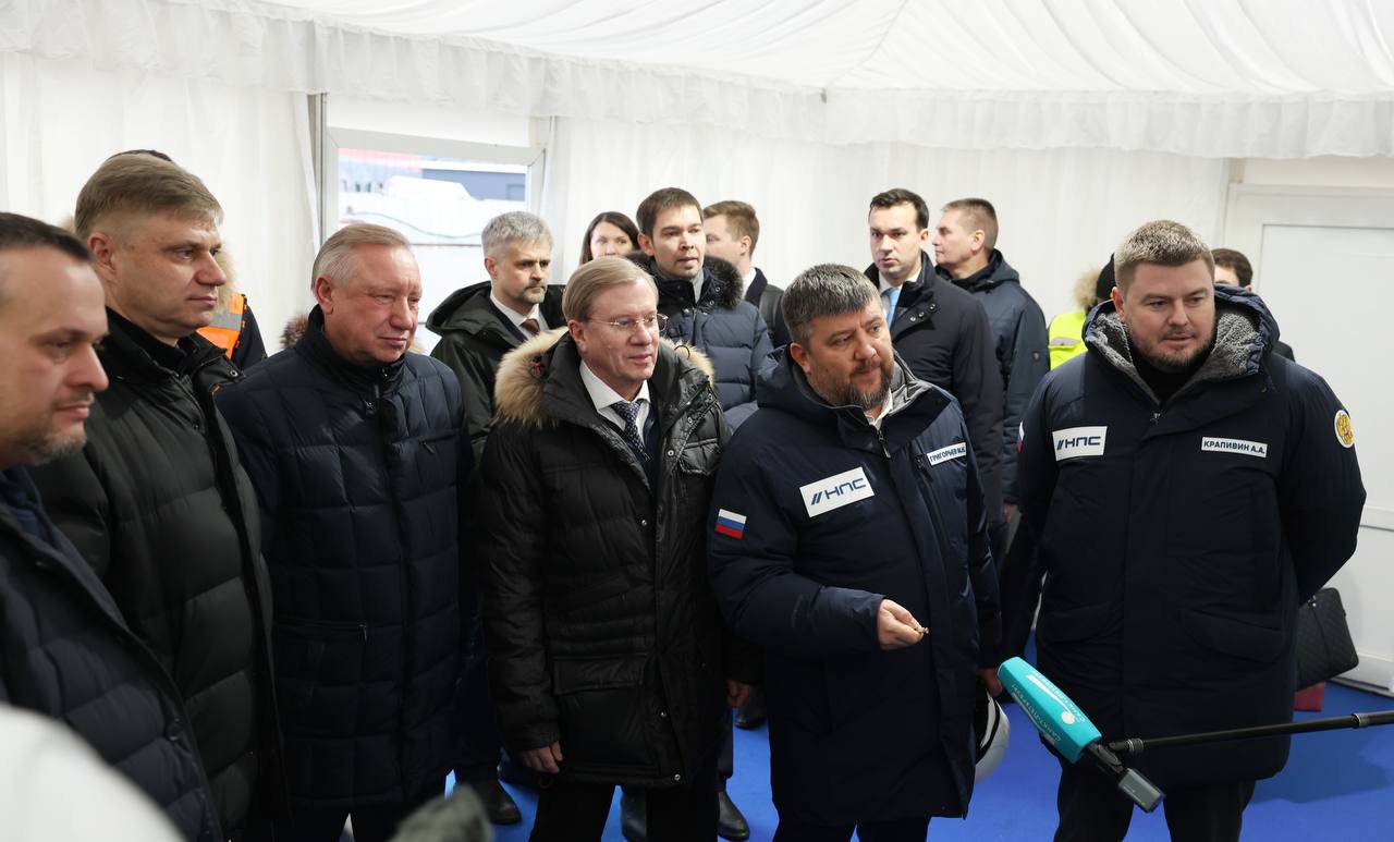 Вице премьер Виталий Савельев министр транспорта Андрей Никитин губернатор Санкт Петербурга Александр Беглов глава РЖД Олег Белозёров и генеральный директор Нацпроектстроя Алексей Крапивин ознакомились с ходом работ на нулевом этапе первой в стране ВСМ Москва Санкт Петербург В ходе мероприятия они посетили участок будущей железнодорожной развязки на входе в северную столицу Ввод этого объекта позволит перевести пригородные поезда на станцию Волковская чтобы разгрузить Московский вокзал под высокоскоростное сообщение Сейчас специалисты компаний НПС ведут здесь подготовку к возведению подпорных стен замене земляного полотна демонтируют нежилые строения в зоне работ Входы в Москву и Санкт Петербург несмотря на малую протяженность одни из самых сложных участков магистрали Здесь плотная городская застройка множество инженерных коммуникаций интенсивный трафик Работы идут вблизи или непосредственно на действующих путях поэтому значительную часть операций нужно вписывать в технологические окна в расписании поездов рассказал Алексей Крапивин глава Нацпроектстроя Специалисты НПС обладают большим опытом работы в подобных условиях в кратчайшие сроки они подготовили инфраструктуру для четырех московских центральных диаметров Нулевой этап ВСМ проходит по территории Санкт Петербурга и Ленинградской области его общая протяженность составляет 13 км Компаниям НПС предстоит возвести здесь 13 мостов и эстакад подготовить территорию под два главных пути реконструировать Московский вокзал построить пригородную станцию Волковская остановочный пункт Сортировочный и ТПУ Южный В работах на нулевом этапе задействовано 1247 человек и 143 единицы техники Реализация всего проекта ВСМ ведется поэтапно Сейчас активные строительно монтажные работы идут в Московской и Тверской областях На других участках выполняются подготовительные работы в соответствии с графиком На всех объектах задействовано 14 тысяч человек и 5 тысяч единиц техники НПС новости ВСМ НПС строим ВСМ