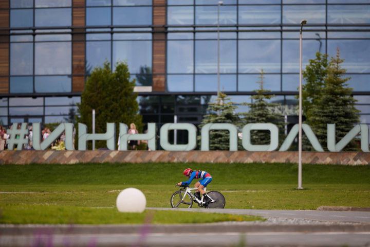 В Иннополисе прошел Чемпионат России по велоспорту В минувшие выходные инновационная столица Татарстана стала центром российского велоспорта. На трассах Иннополиса прошел престижный Альфа-Банк Чемпионат России по велосипедному спорту на шоссе, собравший сильнейших гонщиков со все страны. В церемонии открытия приняли участие: Вице-премьер РТ Роман Шайхутдинов Министр спорта РТ Владимир Леонов Мэр Иннополиса Дмитрий Вандюков Президент Федерации велоспорта России Юрий Кучерявый Президент Федерации велоспорта РТ Ильнур Закарин "Проведение чемпионата в Иннополисе – это знаковое событие для развития велоспорта в регионе. Мы видим, как растет популярность этого вида спорта среди жителей республики", – отметил Владимир Леонов. Помимо профессиональных заездов, организаторы подготовили массовый старт для любителей, в котором приняли участие сотни жителей города и гостей мероприятия. Это позволило создать по-настоящему праздничную атмосферу и приобщить к велодвижению людей разного возраста.