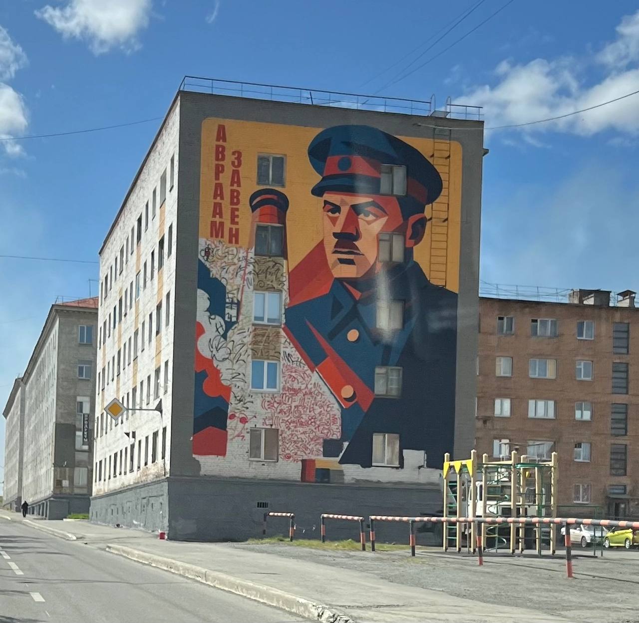 Ошиблись с лицом и местом: в Норильске критикуют новый мурал  На Советской улице в Норильске появился новый мурал, который вызвал у горожан справедливое возмущение. Речь идет о великом человеке, стоявшем у истоков создания Норильска и организации производства мирового масштаба. Только то, как его изобразили, вызывает не только недоумение, но и гнев.  «Сам облик человека на изображении далек от оригинала. Если сравнить с фотографиями, становится очевидно, что работа выполнена без должного уважения и внимания к деталям. Кроме того, размещение мурала на торце дома с окнами нарушает все принципы композиции. Если посмотреть на опыт других городов, например, Красноярска, там муралы размещают на глухих стенах, что делает их эстетически правильными и завершенными. Здесь же мы видим пример халатного подхода, который портит не только облик дома, но и обесценивает память о человеке, который заслуживает гораздо большего», — рассказал депутат ЛДПР Павел Семизоров.  Народный избранник убежден —  это позор для Норильска. Такой мурал недостоин города, депутат считает, что его нужно срочно удалить со стены, и уже готовит запрос с соответствующим требованием.  «Мы не можем позволить, чтобы память о значимых для города людях увековечивалась таким образом. Это требует немедленного исправления», — подвел итог Павел Семизоров.