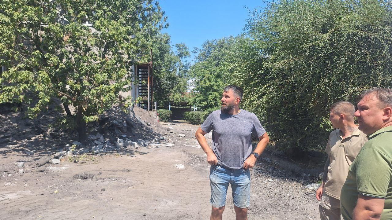 В Мелитополе активно продолжается капитальный ремонт Центра внешкольного образования. Проверка хода работ, проведенная представителями Архангельской области, подтвердила, что на объекте трудятся 12 рабочих и используется 4 единицы техники. На текущий момент выполнены значительные объемы работ: демонтирована старая плоская кровля площадью 1200 м², установлена новая кровельная конструкция на 500 м², а также вывезено около 300 тонн строительного мусора. Следующий этап включает замену старых деревянных окон на новые пластиковые. В планах — установка 92 окон и 19 дверей. Ремонтные работы идут по графику, и здание постепенно преображается, что позволит создать комфортное и современное пространство для творчества и развития детей.