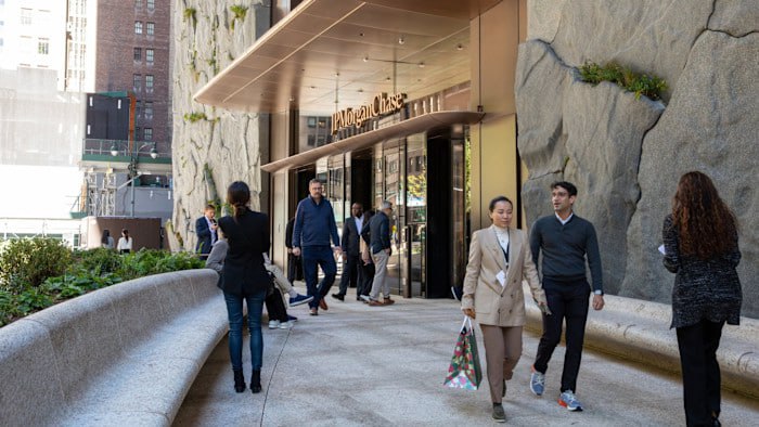 В крупнейших банках США назревает конфликт между поколениями сотрудников из за политики возвращения в офисы Как сообщает Financial Times после распоряжения главы JPMorgan Chase Джейми Даймона о полном отказе от удаленки в компании появилась петиция с просьбой пересмотреть решение ее подписали около 2 тыс из более чем 300 тыс работников по всему миру Однако многие побаиваются открыто выражать несогласие опасаясь последствий для карьеры Один из сотрудников JPMorgan заявил что по его мнению добавление своего имени в петицию будет карьерным самоубийством По данным издания недовольство вызывает не только сама мера но и отношение руководства особенно старшего поколения считающего что работа из дома снижает эффективность Кроме того они испытывают обиду к тому что молодые сотрудники могут гибко работать хотя сами десятилетиями лежали над корпоративными столами отмечает один из банкиров в Лондоне При этом похожие шаги предпринимают и другие корпорации Home Depot Novo Nordisk и Stellantis уже усилили офисные требования фактически отменив гибридный формат Эксперты отмечают что инвестиционный банкинг традиционно придерживается культуры интенсивных часов в офисе К тому же банки вложили миллиарды долларов в новые здания от штаб квартиры JPMorgan на Парк авеню до лондонского офиса Goldman Sachs что подталкивает руководство максимально использовать эти площади Несмотря на усилия топ менеджеров молодые сотрудники продолжают настаивать на гибридной работе Моя команда рассредоточена на двух континентах и трех часовых поясах JPMorgan глобальная компания почему это не может включать мой домашний офис задается вопросом один из сотрудников банка Старый свет больших денег трещит по швам Конфликт поколений выходит на корпоративный уровень сферу в которой традиционно доминируют жесткая иерархия и которая регулируется множеством писаных и неписаных правил Малолетние корпоративные самураи больше не заинтересованы в дорогостоящих символах успеха прошлых поколений английских и итальянских офисных костюмах туфлях на кожаной подошве люксовых часах и аксессуарах Мир Волка с Уолл стрит на наших глазах превращается в музейный экспонат У сторонников жесткого офисного режима осталось два пути либо признать поражение и разрешить сотрудникам работать из дома либо начинать выводит под себя корпоративных рабов с детского сада прививая им любовь к подчинению опенспейсам дресс коду и обязательному присутствию в переговорке уважаемые читатели