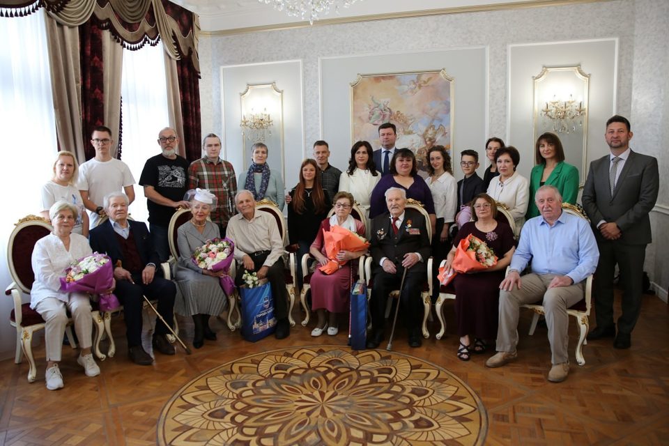 Калужскую пару поздравили с 75 летием совместной жизни В преддверии 654 летия Калуги во Дворце торжеств поздравили юбиляров семейной жизни Борис Алексеевич и Галина Ивановна Костылевы в августе отметили золотую свадьбу Они вместе 50 лет Две пары бриллиантовых юбиляров Вячеслав Егорович и Любовь Никифоровна Голубцовы и Владимир Никитович и Людмила Анатольевна Зубатенко поженились в 1965 году Но самый большой стаж семейной жизни у Николая Игнатьевича и Лидии Иосифовны Апанасовых Они отмечают коронный юбилей 75 лет совместной жизни Николай Игнатьевич и Лидия Иосифовна познакомились по переписке Расписавшись они сыграли четыре свадьбы на родине невесты в Белоруссии на родине жениха в Курской области с соседями и с боевыми товарищами Один из свадебных подарков они хранят до сих пор Это скромный алюминиевый чайник наполненный монетами