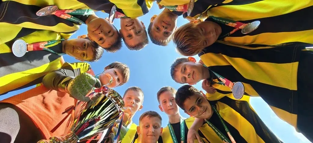 Новороссийские футболисты играли без запасных и завоевали бронзу всероссийского турнира В Геленджике завершился футбольный детско юношеский турнир Весенний Кубок IMSPORT 2026 в котором в возрастной группе 12 13 лет Краснодарский край представила новороссийская команда Факел Всего в этой возрастной категории приняло участие более 20 команд со всей России В борьбе за третье место наши ребята выиграли у футболистов команды Салют из подмосковного города Долгопрудный со счетом 4 2 и завоевали бронзовые медали В состав команды вошли Макар Амирьян Александр Архипов Давид Бабаян Тимофей Баловнев Михаил Галкин Родион Кухтин Илья Макаров Тигран Мелтонян Янис Ордули Матвей Пономарёв Тимур Турков и Дмитрий Чувалов Помимо этого Александр Архипов признан самым ценным игроком в своей возрастной категории а Тимур Турков стал лучшим бомбардиром турнира Тренируются ребята на базе школы 23 в Гайдуке в спортшколе Факел Сергей Юрьевич отметил что практически все игроки из этой же общеобразовательной школы и тренировки проходят на небольшом школьном поле Учитывая что выбирать особо не из кого в состав команд вошли игроки и младше заявленной возрастной категории Я результатом доволен Конкуренты у нас были сильные На воротах в этот раз у нас стоял полевой игрок Саша Архипов вратарь перед турниром повредил ногу И запасных игроков в отличии от других команд у нас не было выложились все и сделали все что смогли Третье место это наша победа отметил тренер команды Сергей Божко и добавил что родители ребят поддерживали команду на протяжении всего турнира за что он им очень благодарен