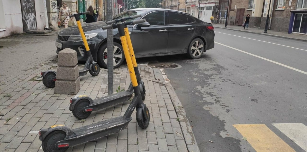 В Ростове изменили порядок парковки и стоянки электросамокатов   В Ростове утвержден порядок организации пунктов размещения средств индивидуальной мобильности  СИМ , в том числе электросамокатов. Постановление подписал и.о. главы администрации города Александр Скрябин. Документ устанавливает целый ряд запретов для размещения стоянок СИМ.    В частности, их нельзя создавать на проезжей части, на велодорожках, на пешеходных тротуарах  если оставшаяся часть ширины тротуара составляет менее двух метров , на клубах и газонах, ближе 15 м от остановок общественного транспорта, на территории и в радиусе 50 м от памятников и объектов культурного наследия.    Кроме того, стоянки СИМ запрещено размещать в арках зданий, на детских площадках, на мостах и путепроводах, ближе пяти метров от подземных переходов, на территории или вблизи  не менее 30 м  от дошкольных, образовательных и медицинских организаций.    Указывается, что СИМ должны размещаться только в пределах согласованной с администрацией и размеченной площадки. Если транспортное средства оставлено мне площадки, то оператор должен самостоятельно переместить его на стоянку. Размер одной стоянки не должен превышать 10 кв. м.    Подписаться на "Новости Ростова"    Прислать новость    Правила размещения комментариев