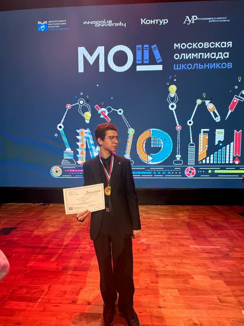Ученик школы № 2120 в ТиНАО стал победителем Московской олимпиады по робототехнике. Учащийся 11 класса Даниил Кубриков блестяще выполнил задание по программированию, решил задачи по физике и робототехнике, а также собрал и запрограммировал устройство, передающее информацию с помощью световых волн. Победа принесла старшекласснику возможность поступить в МФТИ или МГТУ им. Баумана без вступительных испытаний. Талантливый юноша является автором еще нескольких изобретений: робота-спасателя для доставки грузов через местность со сложным рельефом, мини-ракеты, системы распознавания лиц для школьных раздевалок, модели автоматизированной школьной обсерватории, защитной системы блокировки дверей кабинетов. Фото: Московская олимпиада школьников.