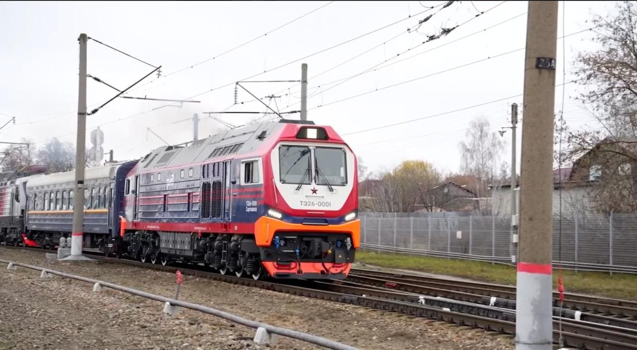 О проведении испытаний нового магистрального грузопассажирского тепловоза ТЭ26 Брянский машиностроительный завод входит в состав АО ТМХ осуществил передачу на испытания магистрального грузопассажирского тепловоза ТЭ26 построенного на производственных мощностях предприятия Данный локомотив представляет собой новейшую разработку инженеров компании ТМХ Инжиниринг 12 ноября на станции Орджоникидзеград Московской железной дороги состоялась церемония отправки тепловоза к месту проведения испытаний в город Коломну Старт мероприятию дал заместитель генерального директора ОАО РЖД начальник Дирекции тяги Дмитрий Пегов Приемочные и сертификационные испытания будут проводиться одновременно на двух локомотивах ТЭ26 на базе Коломенского Научно исследовательского и конструкторско технологического института подвижного состава В рамках рабочего визита на Брянский машиностроительный завод Дмитрий Пегов ознакомился с работой основных цехов специализирующихся на производстве маневровых и магистральных тепловозов Генеральный директор завода Александр Попругин проинформировал о ходе освоения предприятием ремонта тепловозов и организации выпуска локомотивных тележек для российских машиностроительных предприятий В ходе осмотра производственных площадок стороны обсудили вопросы связанные с разработкой и запуском в серийное производство перспективных моделей локомотивов Тепловоз ТЭ26 производства Брянского машиностроительного завода не имеет мировых аналогов Универсальный грузопассажирский односекционный локомотив предназначен для вождения пассажирских и грузопассажирских поездов на малоинтенсивных участках железнодорожной сети а также может быть задействован для выполнения различных хозяйственных и путевых работ Эксплуатация по системе многих единиц допускает одновременное использование до четырех локомотивов что обеспечивает эффективное маневрирование тяговой мощностью при организации перевозок составов массой до 7100 тонн Важнейшей характеристикой магистрального тепловоза ТЭ26 является высокий уровень локализации конструкция локомотива практически полностью состоит из комплектующих отечественного производства Фото из видеоматериала АО ТМХ