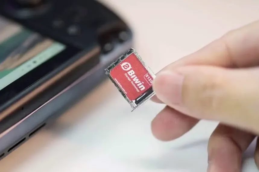 Китай выпускает SSD размером с SIM-карту  Компания Biwin из Китая представила "Mini SSD".  С габаритами всего 15mm x 17mm x 1.4mm, этот маленький SSD обеспечивает скорость чтения до 3,700 MB/s и записи до 3,400 MB/s через интерфейс PCIe 4x2.   Это в разы превышает показатели MicroSD Express, чья скорость достигает лишь 985 MB/s.  Mini SSD доступен в версиях на 512GB, 1TB и 2TB, что делает его универсальным решением для хранения данных.   Кроме того, устройство защищено по стандарту IP68 от воды и пыли, а также выдерживает падения с высоты до трех метров.    Уже анонсировано использование этого SSD в двух игровых портативных консолях — GPD Win 5 и OneXPlayer Super X.   На данный момент информация о ценах и доступности продукта остается под завесой тайны.   ================   News     Soft     Gear     Links