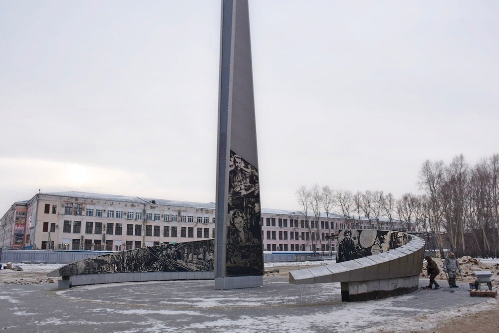 Площадку вокруг стелы города Трудовой доблести благоустроят к концу ноября  7 ноября приёмочная комиссия Комсомольска-на-Амуре приняла работы по благоустройству сквера Трудовой славы на проспекте Ленина у швейной фабрики. Специалисты управления дорожной деятельности, депутаты городской думы и члены Общественного совета осмотрели объект и одобрили проведённые работы.  На обновлённой территории вырубили аварийные деревья и снесли пни, оставшиеся деревья подстригли. Также заменили старый асфальт и бордюры, проложили дорожки из брусчатки, установили освещение и камеры видеонаблюдения, добавили скамейки, урны, велопарковку и информационные таблички. Территория озеленена новыми деревьями, кустарниками и газонами. Общая стоимость работ составила 11,4 млн рублей. Дополнительно один из банков профинансировал установку четырёх брендированных скамеек. Этот сквер для благоустройства выбрали сами горожане на прошлогоднем голосовании.  Территория у швейной фабрики обширная, поэтому благоустройство продолжается. Часть, расположенная ближе к улице Шиханова, уже приведена в порядок по федеральной программе. Вторая зона, находящаяся ближе к улице Васянина, благоустраивается за счёт краевых средств. Здесь работы ведутся вокруг стелы «Комсомольск-на-Амуре — город Трудовой доблести» и завершатся к концу ноября.