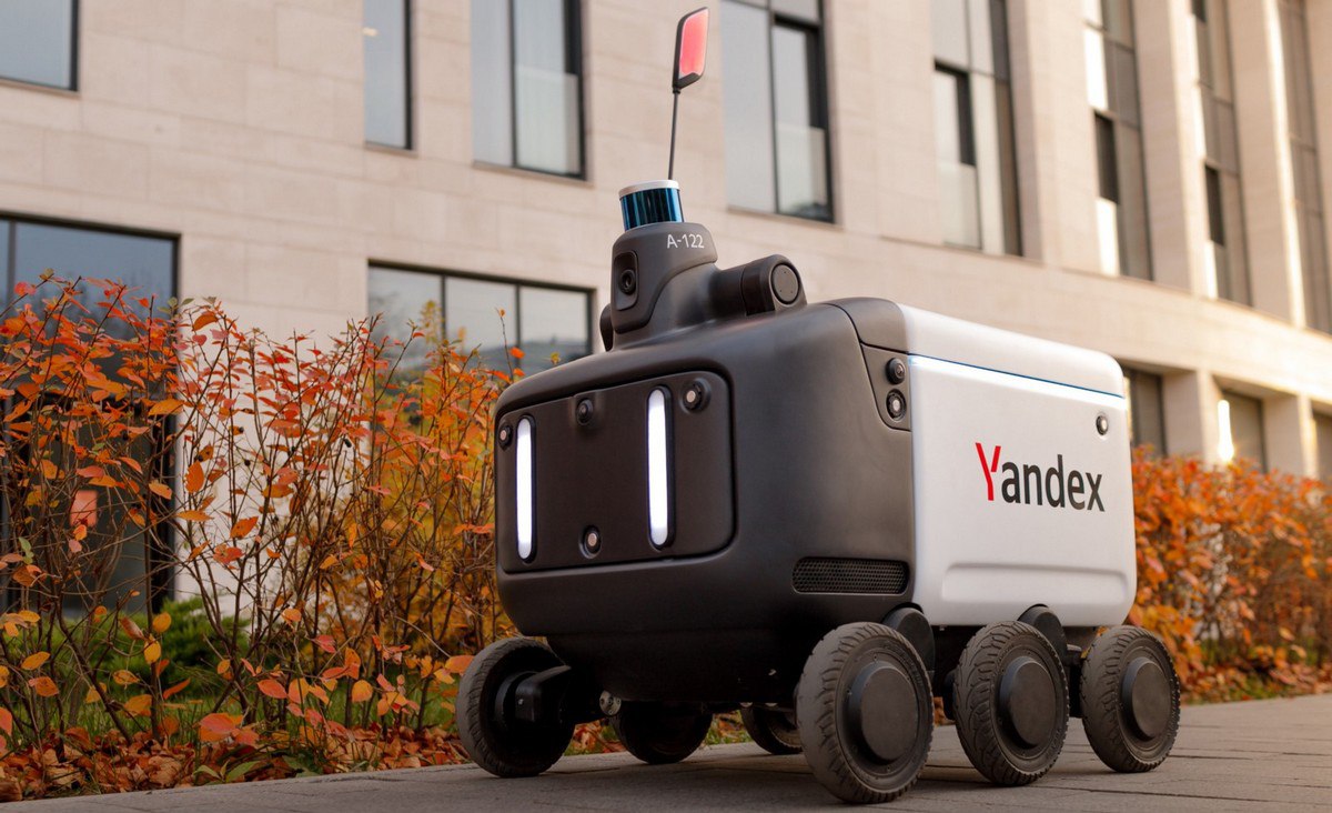 Для роботов доставщиков разработают ГОСТы Первые ГОСТы на роботов доставщиков могут быть утверждены в России уже в 2026 году работа над нормативами уже стартовала О планах стандартизировать роверы для доставки рассказал глава Росстандарта Антон Шалаев Эта работа уже начата и в 2026 году у нас должны появиться требования пока не по интегрированию роверов в уличное движение а именно по классификации и общим требованиям безопасности Шалаев не сообщил кто именно занимается разработкой новых стандартов но догадаться не сложно скорее всего это делает Яндекс Ну во первых именно его роботы уже занимаются доставкой в нескольких городах страны а за ближайшие три года количество доставщиков увеличится с нынешних 150 160 до 2 6 тыс штук Всё благодаря ЭПР в рамках которого работать роверы начнут в 37 регионах страны А во вторых именно Яндекс разработал несколько ГОСТов которые начали действовать с 1 января Правда касаются они внедрения промышленных роботов Предполагается что стандарты упростят взаимодействие производителей и интеграторов при разработке совместимых решений   МашТех