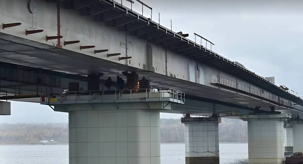 На Чусовском мосту ремонтные работы начались сразу на нескольких участках В Прикамье подрядчик развернул работы по ремонту Чусовского моста сразу на нескольких участках. По данным минтранса, на старом мосту уже сняли асфальт, демонтировали ограждение и освещение. Сейчас рабочие удаляют слой старой гидроизоляции. В районе Пальниковской развязки проходит сборка надземного пешеходного перехода. Далее его установят на опоры. Также на этом участке подрядчик построит тротуары на съездах – они расположатся с обеих сторон дороги. Строятся тротуары и в районе улицы Корсуньской – они уже отсыпаны щебнем. Здесь же будет построен съезд к газовой заправке. Одновременно идет согласование с РЖД графика работ по реконструкции железнодорожного путепровода на перегоне Левшино – Голованово. Как сообщалось ранее, работы по реконструкции объекта должны завершиться в 2027 году. >