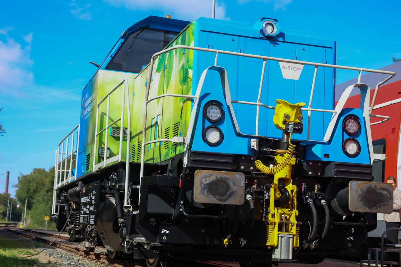 Alstom оборудовала локомотив двигателем прямого сжигания водорода Alstom завершила создание опытного образца маневрового локомотива на водородной тяге взяв за основу серийный дизельный экземпляр Локомотив оснастили двигателем переоборудованным для прямого сжигания водорода При отсутствии выбросов углекислого газа такой двигатель выбрасывает окислы азота но разработчики проекта утверждают что в процессе его реализации им удалось минимизировать эту проблему Особенность водорода в том что его можно сжигать с большим избытком воздуха При переоборудовании маневровых локомотивов мы целенаправленно используем это свойство чтобы стабилизировать горение повысить эффективность и в то же время свести к минимуму образование оксида азота Мы активно работали над конструкцией турбонаддува выхлопных газов поскольку большой избыток воздуха представляет собой особую проблему доктор Петер Эйтс руководитель Института двигателей внутреннего сгорания и топливных элементов Брауншвейгского технического университета профессор Компания представила водородный локомотив на своей площадке в Зальцгиттере где также провела первые тестовые испытания Испытания локомотива планируется продолжить на сталелитейных заводах Salzgitter Group до октября 2025 года для оценки эффективности водородной технологии при эксплуатации локомотива на предприятии Для Salzgitter Group участие в проекте актуально на фоне реализации группой программы по переводу производства чугуна с доменного процесса на прямое восстановление сначала преимущественно с использованием природного газа а затем с использованием водорода Проект по модернизации локомотива реализуется в партнерстве с VPS Verkehrsbetriebe Peine Salzgitter GmbH дочерняя компания Salzgitter AG WTZ Roßlau gGmbH Техническим университетом Брауншвейга и Институтом технологии слоев и поверхностей имени Фраунгофера Городские власти Зальцгиттера также поддержали проект выделив на него 1 5 млн Собранные по итогам испытаний данные будут проанализированы для оценки перспектив модернизации маневровых тепловозов на водородную тягу Как сообщили в Alstom результаты испытаний послужат основой для принятия решений о том может ли перевод маневровых тепловозов на водородную тягу стать основным решением по снижению выбросов для Германии и Европы Фото Alstom tzdjournal
