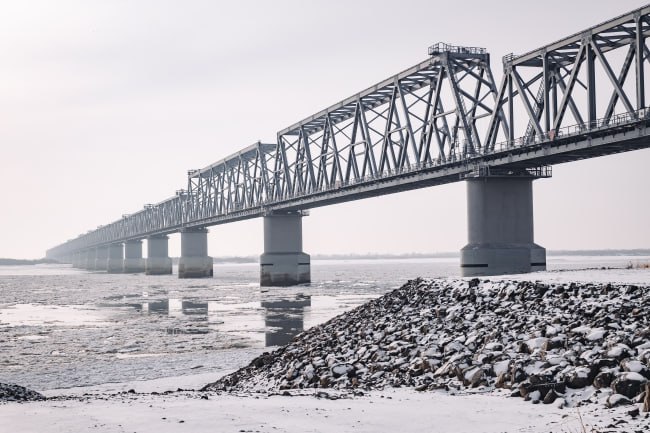 Новый мост открыли в Мирнинском районе  Новый мост открыли в Мирнинском районе Якутии. Старт движения по автомобильной переправе через реку Чуоналыр на 30 километре трассы «Анабар» 15 ноября дал глава региона Айсен Николаев. Объект отремонтировали по нацпроекту «Безопасные качественные дороги».   Мост построили в 70-х годах прошлого столетия. Он находился в аварийном состоянии. Руководство республики приняло решение реконструировать его после обращений местных жителей. Работы контролировал глава Якутии.   Теперь у жителей Мирнинского, Анабарского и Оленекского районов есть бесплатное круглогодичное автомобильное сообщение. Также мост имеет важное значение для региона, обеспечивая подъезд к лыжной трассе, а также уникальной зоне экологического туризма и активного образа жизни в Мирнинском районе.  Общая протяженность переправы вместе с подходами составила больше одного километра, сам мост – 80 метров. Чтобы обеспечить безопасность дорожного движения, установили 594 погонных метров барьеров, 33 сигнальных столбика и 62 дорожных знака.  Фото: Малахов Андрей