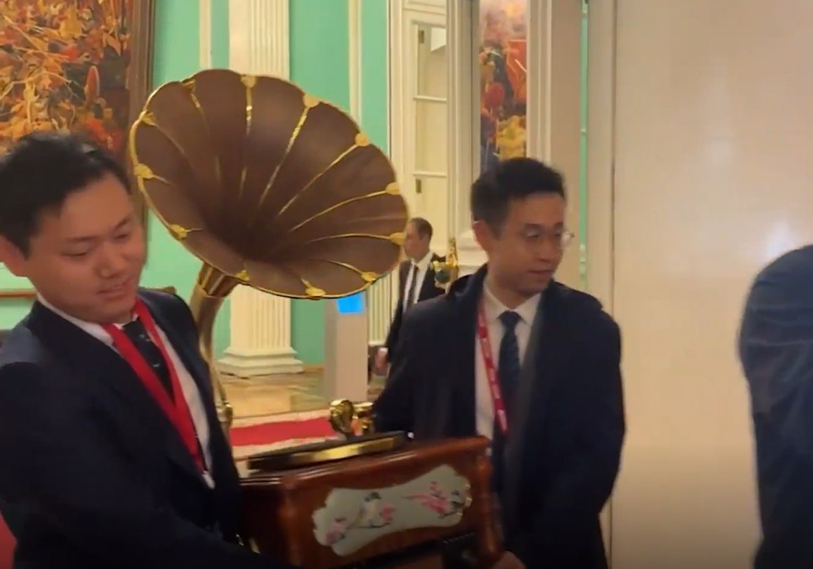 Китайская делегация принесла в Кремль граммофон Это подарок Путину. Граммофон выполнен из темного дерева и украшен лаковой миниатюрой в дальневосточном стиле, изображающей птиц на ветвях весеннего цветущего дерева. Кроме граммофона, гости из Китая принесли богато украшенный резьбой в китайском стиле консольный столик и другие сувениры. Байки лаовая. Китай. Новости