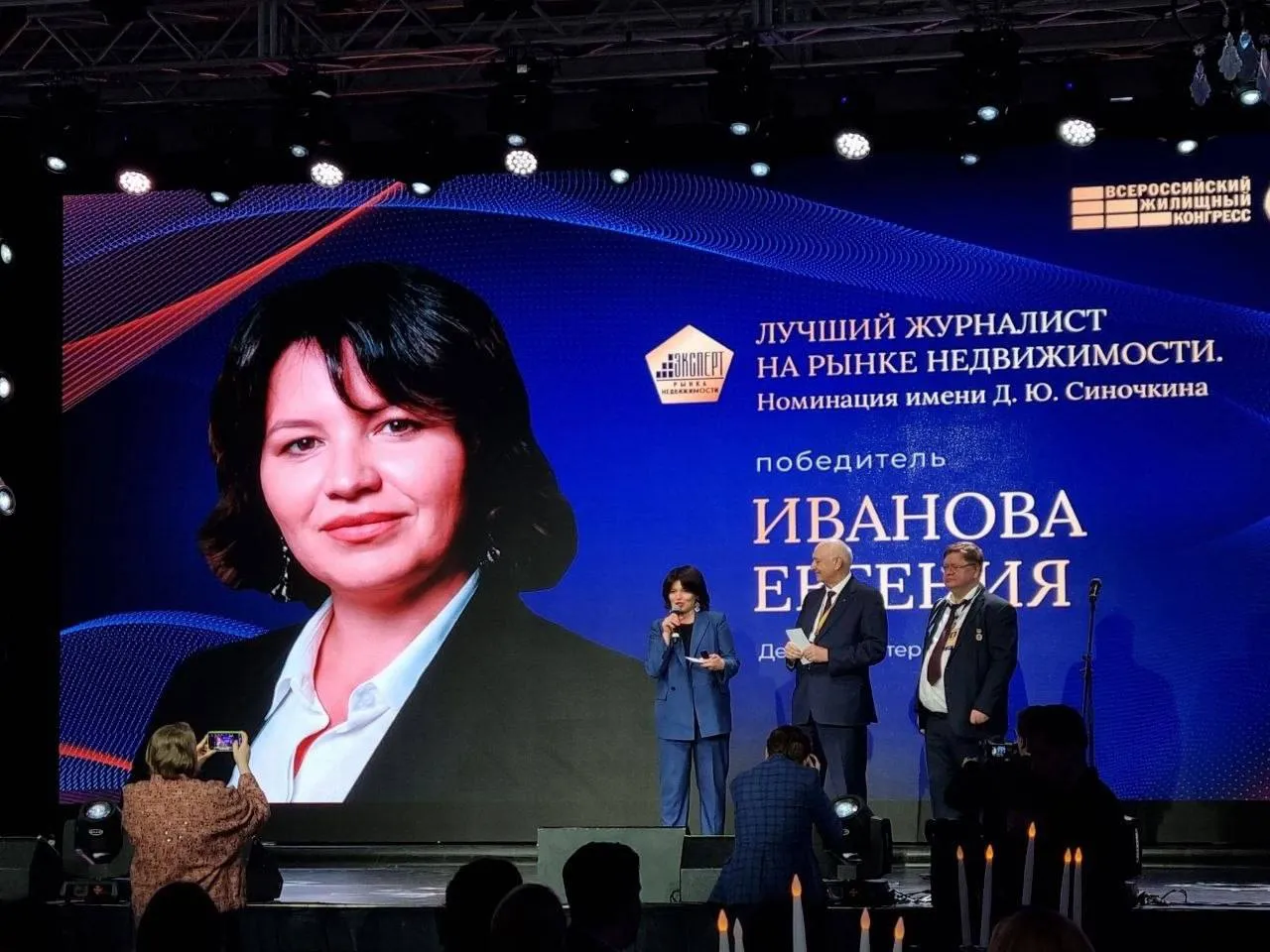 Первым лауреатом журналистской премии на Жилищном конгрессе стала автор Делового Петербурга Победителем выбрали корреспондента ДП Евгению Иванову Евгения работает в медиа более 20 лет Профессиональную деятельность начала в 2003 году корреспондентом отдела Строительство газеты Недвижимость и строительство Петербурга С 2019 года сотрудник редакции газеты Деловой Петербург Редактор проектов модератор отраслевых мероприятий Очень приятно получить премию а точнее признание экспертного сообщества Очень люблю свою работу новости рынок недвижимости всех ньюсмейкеров Давайте делать рынок более прозрачным и понятным со своей стороны мы всегда открыты к взаимодействию и всегда рады видеть вас на страницах Делового Петербурга и на наших мероприятиях поделилась Евгения Иванова Номинация сотрудников СМИ на Жилищном конгрессе названа в честь журналиста Дмитрия Синочкина бывшего главного редактора журнала Пригород и шеф редактора портала Недвижимость и Строительство Петербурга признанного лучшим журналистом России по версии Национальной премии Эксперт рынка недвижимости Церемония подведения итогов премии Эксперт рынка недвижимости 2026 прошла 15 апреля С 2018 года ее аудиторией являются эксперты рынка недвижимости руководители риелторских и строительных организаций а также специалисты в области информационных ресурсов и технологий Премия была вручена на конгрессе впервые Всероссийский жилищный конгресс Подписаться на ДП в Telegram MAX