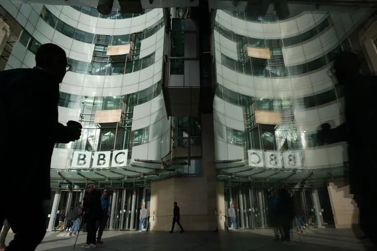 Британская вещательная корпорация BBC планирует сократить от 1 8 тыс до 2 тыс сотрудников почти каждого десятого журналиста на фоне финансовых трудностей Об этом сообщает само издание Как заявил исполняющий обязанности гендиректора Родри Талфан Дэвис компании необходимо сэкономить около 500 млн фунтов стерлингов 678 млн в течение ближайших двух лет Он не исключил что под сокращение могут попасть целые каналы или сервисы По словам Дэвиса руководство намерено пересмотреть все чтобы найти баланс между экономией и сохранением ключевых радио телевизионных и онлайн продуктов При этом он признал что предстоящие сокращения станут очень тяжелой новостью для сотрудников В BBC отметили что разрыв между доходами и расходами растет на фоне высокой инфляции в производстве сокращения лицензионных сборов и нестабильной мировой экономики В связи с этим также вводятся ограничения на найм командировки и расходы на услуги внештатников Сейчас в корпорации работает около 21 5 тыс человек Окончательные решения о масштабах и структуре сокращений будут представлены позже в этом году Планы уже вызвали критику со стороны профсоюзов В отрасли предупреждают что такие меры могут подорвать способность BBC выполнять свою общественную миссию и негативно скажутся на качестве журналистики В феврале стало известно что американское издание The Washington Post объявило о масштабном сокращении сотрудников которое затронет редакцию и бизнес подразделения издания Компания планирует уволить около 30 персонала включая более 300 журналистов из примерно 800 сотрудников редакции Сокращения коснутся спортивного локального и международного направлений Коллектив криптоканала напоминает читателям что формально основным источником финансирования и BBC рупора британской пропаганды является телевизионный лицензионный сбор Это обязательный ежегодный платеж на 2026 год около 180 фунтов с домохозяйства который обязаны платить все британские домохозяйства компании и организации использующие оборудование для просмотра или записи живого телевидения или сервиса BBC iPlayer Этот сбор собирается напрямую от населения и составляет основную часть доходов BBC по состоянию на 2024 2025 годы сумма составил около 3 8 млрд фунтов в год Фактически это деньги британского правительства которое администрирует весь этот процесс Еще около 30 бюджета компании около 100 млн фунтов в год прямые гранты правительства Великобритании Другую заметную часть бюджета BBC составляют пожертвования международных фондов включая Gates Foundation USAID для Media Action и др Сокращение доходов главной британской медиакорпорации почти на 10 это примерно как если бы в России начали сокращать бюджеты на многочисленные проекты Владимира Соловьева и Маргариты Симоньян Денег у британского правительства на пропаганду стало сильно меньше и судя по ситуации на Ближнем Востоке дефицит бюджета будет только нарастать покрывать его физически нечем В этой связи в очередной раз хотим напомнить позиция России в отношении любых проблем и конфликтов на Запада и особенно в Великобритании самом последовательном и упорном противнике России всегда должна быть однозначной и бескомпромиссной чем хуже тем лучше уважаемые читатели