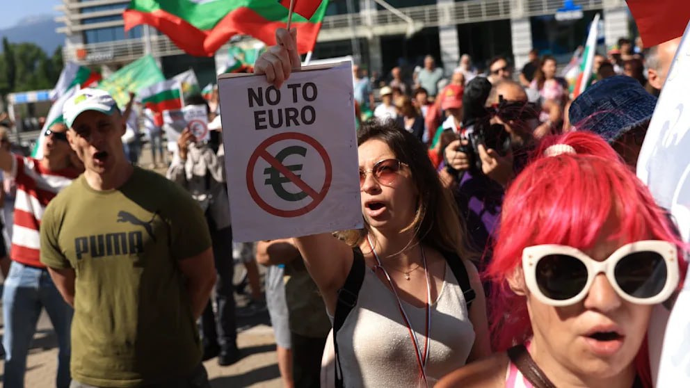 «Евро? Нет, спасибо!» — в Болгарии прошли демонстрации против введения евро С одобрения Еврокомиссии и Европейского ЦБ, с 1 января 2026 года евро должен заменить болгарский лев. Однако тысячи людей вышли на улицы, чтобы выразить свой протест против этого. В Софии возле Болгарского народного банка демонстранты сказали «Нет евро», причём протестуют не только националисты, выступающие против «евроколонизации». Болгар злит, что их собственное правительство не дало народу возможность самому высказаться по поводу судьбы национальной валюты. На референдуме результат мог бы быть в пользу лева: согласно опросу середины мая, более половины 54,9% против введения евро. Люди опасаются роста цен и ослабления экономики. В Брюсселе возражают: как заявила председатель Еврокомиссии Урсула фон дер Ляйен, болгарская экономика станет сильнее и получит выгоды от торговли в еврозоне, прямых иностранных инвестиций и доступа к финансовым ресурсам. Противников евро эти заявления не убеждают. Их альянс требует проверки данных, на основе которых эксперты Европейского ЦБ пришли к выводу, что Болгария соответствует критериям перехода на евро. Если эти данные неверны, вступление Болгарии в еврозону может обернуться катастрофой по примеру Греции. Кроме того, аргументируют протестующие, Болгария не готова и по другим параметрам — она является «одним из важнейших центров по производству фальшивых евро-банкнот» и страдает от «климата коррупции, организованной преступности и цензуры в СМИ».