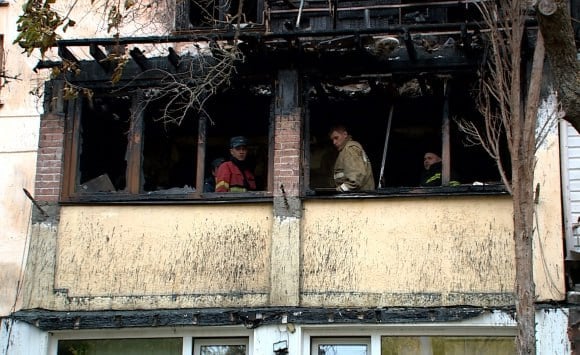 Последствия пожара устраняют в многоквартирном доме на улице Хрусталёва  Крышу в пятиэтажке на улице Хрусталёва укрепят до конца дня, сообщил замдиректора Управляющей компании «Центр».   Напомним, 20 ноября в доме №17 случился пожар, который унёс жизнь пожилого мужчины. По информации управляющей компании, огонь уничтожил крышу, от него пострадало семь квартир, ещё три – затопило.  К вечеру среды в пятиэтажке восстановили подачу электричества, воды и газа. Исключением стали квартиры, где отсутствовали хозяева или промокла проводка. Сейчас специалисты УК «Центр» занимаются работами по сохранности кровли: изготавливают укрепляющие конструкции.  МУХАММАДЖОН ЖАЛОЛОВ, заместитель директора Управляющей компании «Центр»: «В части кровельного покрытия мы проводим подготовительные работы к ухудшению погодных условий. А именно: проводим работы по сохранности кровельного покрытия, усиливаем покрытие к несущим конструкциям, чтобы в период погодных условий кровля не слетела с объекта. Работы планируем закончит сегодня, до конца».  Укреплением крыши занимаются восемь человек. По словам замдиректора управляющей компании, чтобы уложиться в сжатые сроки, работать пришлось в круглосуточном режиме.  ЕВГЕНИЙ ГУРЕВИЧ, кровельщик Управляющей компании «Центр»: «Производится распил досок, потом они поднимаются наверх, так как в слуховое окно подать шестиметровое это невозможно, крыша соединяется в нужную длину и крепится на недостающие элементы, которые сгорели».  Кровельщики заверили: самые слабые участки уже укрепили, и крыша прошла испытание первым дождём. Список дальнейших работ будет составлять комиссия по чрезвычайным ситуациям.  Сейчас на месте работают специалисты МЧС, которые разгребают завалы, сотрудники Следственного комитета проводят проверку.    НТС - Новости Севастополя