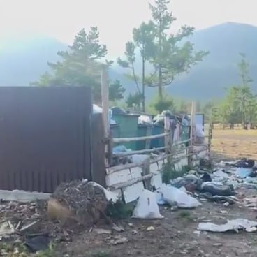 В Ольхонском районе пожаловались на свалку вблизи Байкала  Скопление мусора у территории Прибайкальского нацпарка беспокоит жителей деревни Курма. Контейнеры для мусора там не оборудованы крышками, а вокруг отсутствует ограждение. Ветер разносит отходы на территорию учреждения.   Это не первый раз, когда в Курме сталкиваются с такой проблемой. Год назад местные также жаловались на свалку отходов. Мусорка не только вредит байкальской природе, но и привлекает диких кабанов и медведей. Местные власти не решают проблему.  Также говорят и о ее системности. Жалобы на скопления мусора неоднократно направляли на Прямую линию президента. В 2023 году таких обращений было 17, а годом позже – 14. Сейчас направлено обращение в природоохранную прокуратуру с просьбой найти виновных и устранить нарушения.