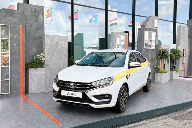 АвтоВАЗ представил Lada Aura для такси На Петербургском экономическом форуме АвтоВАЗ представил стретч-седан Lada Aura в модификации для такси. Автомобиль дебютировал в белом цвете с желтой полосой по подоконной линии и "шашечками" на передних и задних крыльях. Кресла новинки обшиты стеганой экокожей, руль оформлен в более демократичной манере, чем в других версиях Aura. Автомобиль укомплектован подушками не только для передних, но и для задних пассажиров, сзади предусмотрен также собственный пульт управления подогревом и USB-порты. Розничные продажи бизнес-седанов Lada Aura начались в России 30 ноября 2024 года. Модель представлена в двух комплектациях стоимостью от 2,6 млн рублей. Диана Загртдинова / ТАСС