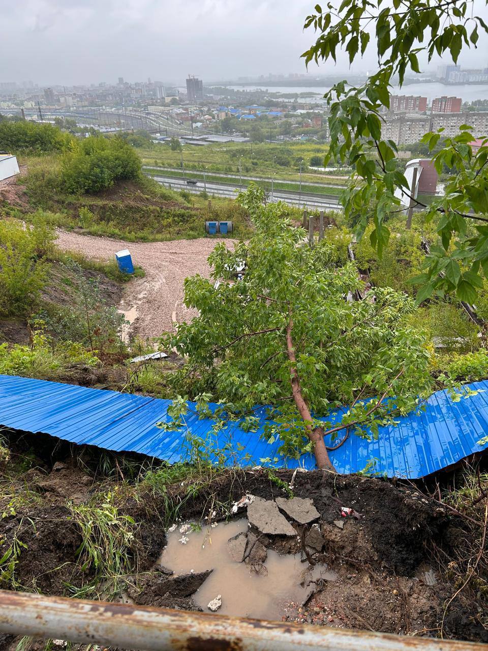 В Красноярске на 2-ой Огородной снова сошёл грунт из-за обильных дождей.   Поврежден забор, появилась трещина в районе новой ливневой канализации.   На месте работают специалисты, которые занимаются укреплением размытого склона.  _________  Оставить обращение