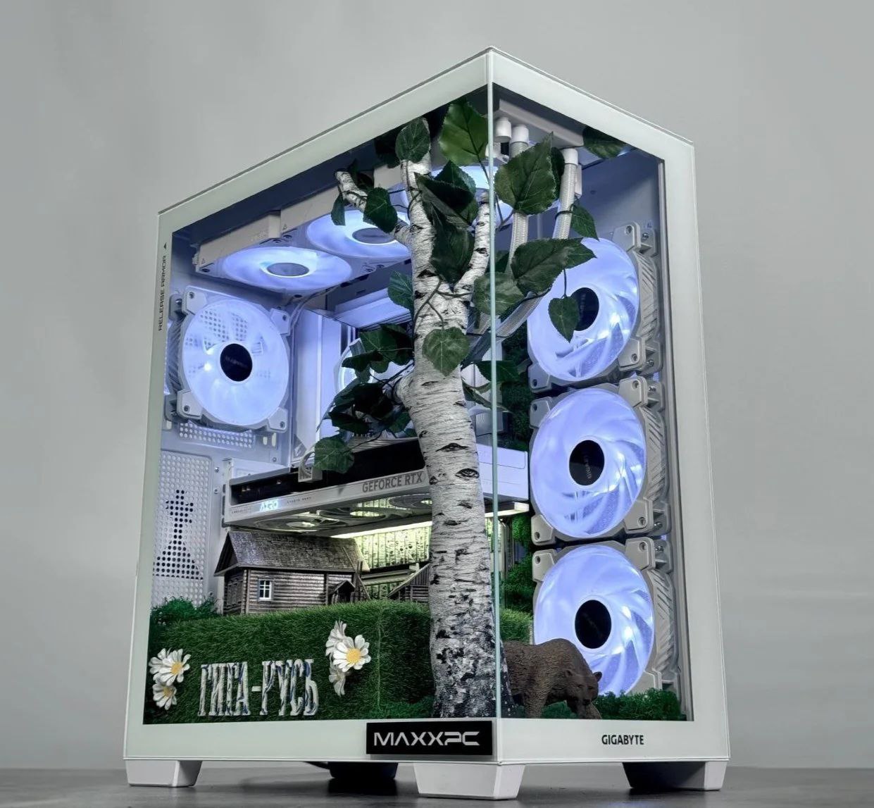 В России собрали скрепный ПК ко Дню народного единства Это ГИГА РУСЬ для игры в Смуту Кастомный ПК изготовила команда MaxxPC совместно с GIGABYTE Белый ПК украшен гжелью и композицией из пластиковой березы и деревянной избы с колодцем на зеленой опушке Декоративные элементы видны через прозрачную панель и подсвечиваются встроенной в систему охлаждения RGB подсветкой На борту Ryzen 7800X3D видеокарта RTX 5060Ti 16 ГБ 32 Ггб ОЗУ DDR5 и террабайтный SSD