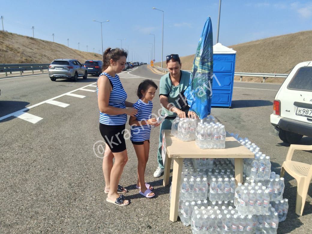 На подъездах к Крымскому мосту организовали две точки выдачи воды  По информации администрации Темрюкского района, вдоль трассы со стороны Тамани по направлению к Крымскому мосту организованы две точки, где водителям и пассажирам, ожидающим проезда, выдают бутилированную воду. Этим занимаются 4 волонтера. Также на этом участке установлены 11 биотуалетов.  На 17:00 В очереди на ручной досмотр со стороны Тамани находится 915 транспортных средств. Время ожидания около трех часов.  В очереди на ручной досмотр со стороны Керчи находится 460 транспортных средств. Время ожидания около двух часов.  Ваши видео высылайте нам в бот     Подпишись поделись      Прислать  видео новость