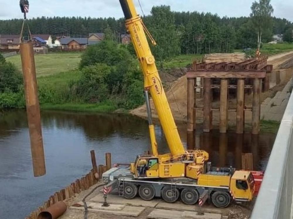Через реку Вель строится временный объездной мост Подрядчик завершил расчистку полосы отвода и приступил к устройству подходов и монтажу пролетных строений временного объездного моста. Движение по нему будет запущено к началу осени. В рамках капремонта будут заменены железобетонные опоры, мостовое полотно, пролетное строение. Мостовики также обустроят водоотвод и освещение, выполнят работы на сопряжениях и конусах. Задачи довольно масштабные, поэтому объект является переходящим, его введут в эксплуатацию в конце ноября 2026 года. Фото пресс-службы областного правительства