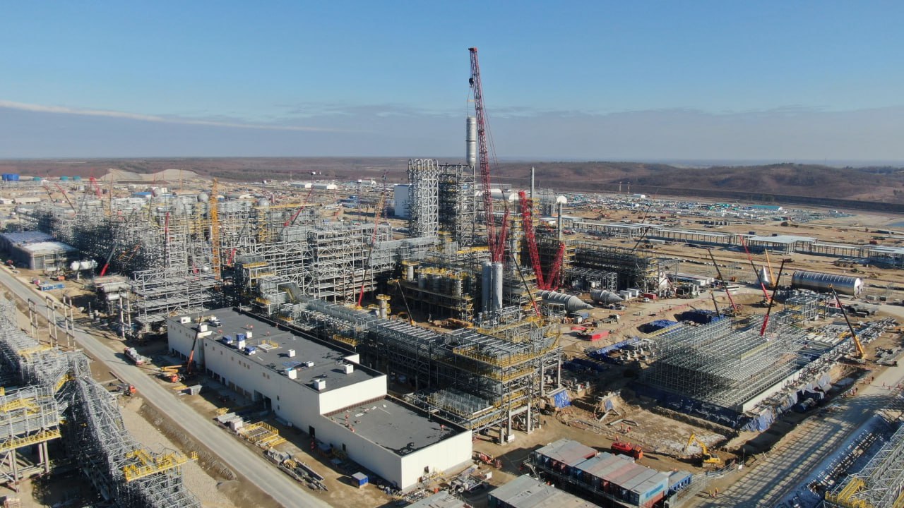 Амурский ГХК тянет полиэтилен Первый полиэтилен Амурского газохимического комплекса АГХК планируется выпустить в третьем квартале 2026 года, сообщил журналистам гендиректор компании Сергей Сергеев. По его словам, готовность ГХК на сегодняшний день составляет 76%. К концу текущего года будет достигнута механическая готовность по двум установкам. "Это полностью построенные установки, на которых уже приступили к тестированию и испытанию оборудования без приемки сырья. А на будущий год мы планируем выйти на выпуск товарной продукции — в III квартале следующего года", — сказал Сергеев, его цитирует "Интерфакс". Начало выпуска полипропилена намечено на 2027 год. Проект строительства Амурского газохимического комплекса реализует "Сибур" совместно с китайской Sinopec. Изначально проект базировался на европейских технологиях и оборудовании, в частности, Linde и Technimont. После февраля 2022 года эти компании остановили участие в проекте, в результате чего "Сибуру" и Sinopec пришлось пересмотреть конфигурацию проекта, сменить подрядчиков и лицензиаров. Это привело к сдвигу сроков его запуска на два года. После ввода в эксплуатацию завод будет выпускать 2,3 млн тонн полиэтилена и 0,4 млн тонн полипропилена в год. В качестве сырья будут использоваться этан и СУГ со строящегося Амурского газоперерабатывающего завода "Газпрома".