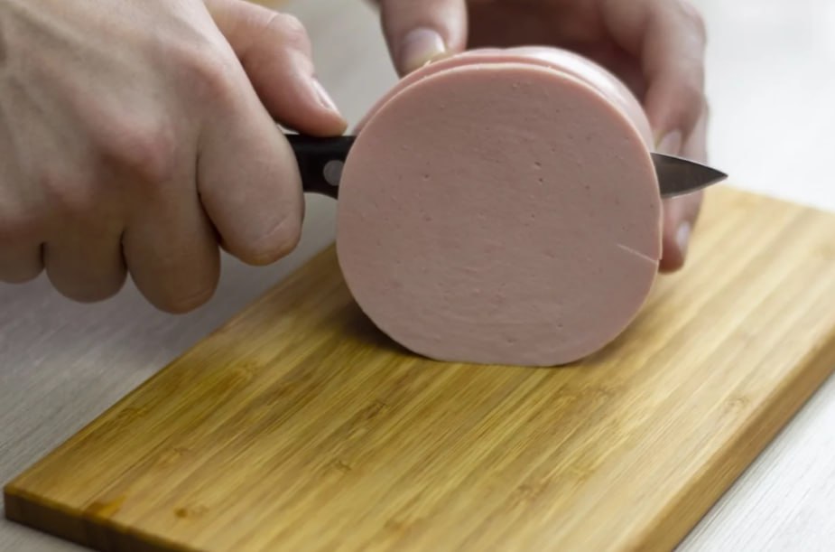 На Камчатке в варёной колбасе нашли запрещённый «мясной клей»  С 30 января по 13 августа 2025 года Камчатский филиал ФГБУ «НЦБРСП» провёл 308 исследований колбасных изделий из мяса и субпродуктов птицы. Проверки, выполненные в рамках государственного задания и платных услуг, оценивали соответствие продукции требованиям технических регламентов Таможенного союза.    Лаборатория исследовала образцы на содержание антибиотиков, сырьевой состав  ДНК , микробиологические показатели, токсичные элементы и другие параметры качества и безопасности. В варёной докторской колбасе и замороженных сосисках  их название в ведомстве не раскрывают. - Прим. ред.  была обнаружена микробная трансглютаминаза — фермент, запрещённый в России из-за недоказанной безопасности.    Как пояснили специалисты, эта добавка используется для улучшения текстуры и увеличения массы продукции, но может наносить вред здоровью, повреждая слизистую кишечника и повышая антигенную нагрузку на иммунную систему. Информация о нарушениях передана в систему «Веста» и владельцам продукции.    Подписаться   Предложка   ЧАТ  САЙТ – kamchatka.aif.ru