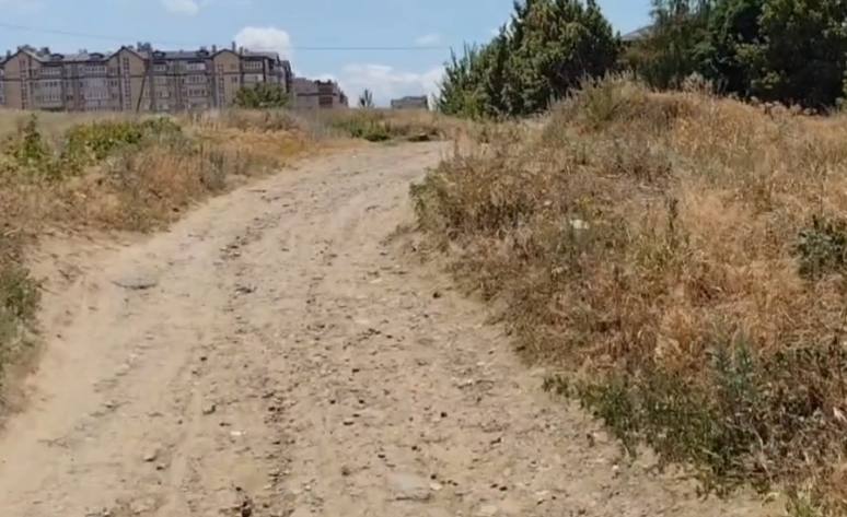 В Ростове вновь перенесли сроки строительства дороги к Вертолётному полю. Власти уже 7 лет не могут найти денег, чтобы заасфальтировать 500 метров.  В Ростове к строительству дороги на Тружеников от 2-й Краснодарской до Батуринской планируют приступить в 2026 году. Но, как следует из ответа мэрии города денег пока нет.   «При условии выделения финансирования приступить к началу реализации проекта планируется в 2026 году», — сказано в ответе.   Речь идёт о строительстве 500-метровой дороги к Вертолётному полю, о которой местные жители просят с 2014 года, то есть практически с самого заселения.  Участок на Тружеников от 2-й Краснодарской до Батуринской — один из самых важных: если его построить, то заезжать в микрорайон можно сразу с проспекта Стачки.  В 2018 году власти Ростова уже планировали строительство этой дороги, но тогда в бюджете не хватало 5,3 млн на разработку проекта. Рассмотрение вопроса отложили до 2020 года. В 2023 году разработку проектно-сметной документации всё же завершили, она получила положительное заключение Госэкспертизы.   Тогда же власти сообщили, что при условии выделения денег строительство дороги начнут в 2024 году. Финансирование так и не нашли и вновь перенесли сроки уже на 2024-2025 годы.  Как сообщили в администрации Ростова, строительство дороги оценивается в 90,5 млн рублей. Но это в ценах на IV квартал 2022 года. Очевидно, что стоимость работ с тех пор значительно выросла.  Сейчас дорога представляет собой земляную насыпь протяжённостью 500 метров, местами сужающуюся до пешеходной тропы. В сухую погоду здесь можно заметить доски, автомобильные покрышки и прочий мусор, торчащий прямо из земли. Но после дождя всё превращается в грязевое месиво, которое не могут преодолеть даже пешеходы.