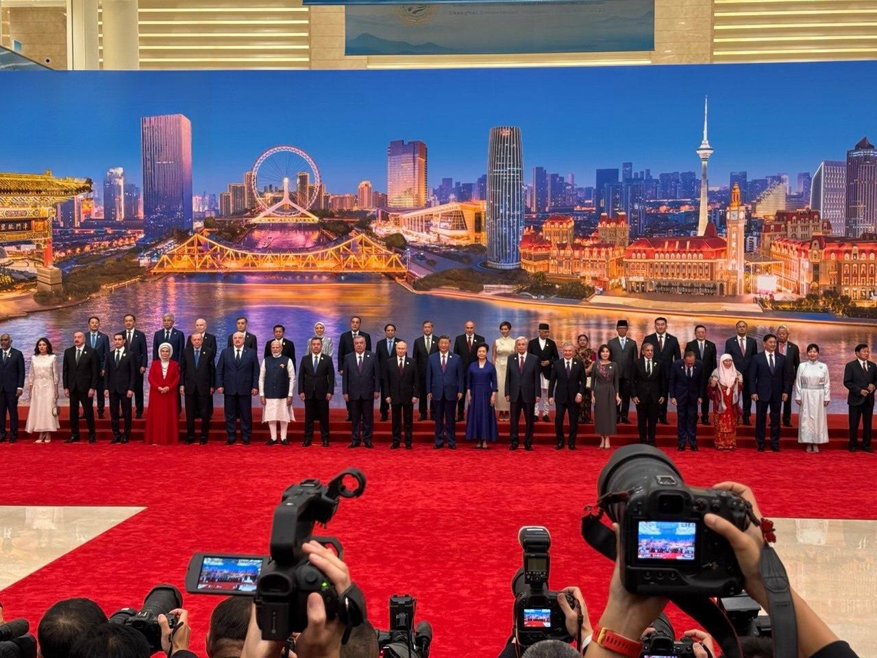 На совместной фотографии лидеров прибывших для участия в саммите ШОС видно что Пашинян Алиев и Эрдоган присутствуют с супругами