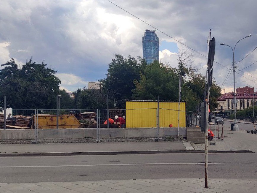 В Екатеринбурге начались активные строительные работы на улице Воеводина — между Музеем ИЗО и заброшенным павильоном «Цветы».  На участке появилась бытовка для рабочих, сооружено бетонное основание для будущего забора, в которое уже вбиты опоры.