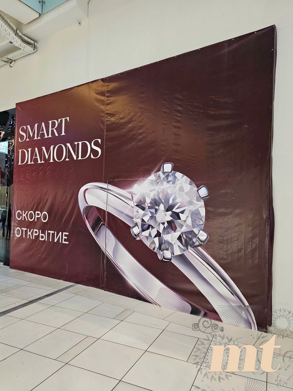Готовятся к открытию первые магазины по продаже искусственных бриллиантов До конца 2025 г сеть 585 Золотой откроет четыре магазина в которых будут представлены только украшения с искусственно выращенными бриллиантами в Москве Краснодаре Красноярске и Новосибирске Лабораторные бриллианты выращенные в контролируемых условиях химически идентичны природным оба состоят из чистого углерода с той же кристаллической решеткой твердостью 10 по Моосу и оптическими свойствами Основное отличие в происхождении природные формируются за миллиарды лет в мантии Земли под естественным давлением часто содержа азотные примеси или минеральные включения в то время как лабораторные создаются за 3 12 недель без таких естественных дефектов что делает их чище и более однородными по цвету Различия заметны только под специальным оборудованием то есть покупатели в повседневной жизни никаких отличий не заметят При этом в среднем лабораторный бриллиант дешевле природного примерно на 60 80 при одинаковых характеристиках по цвету чистоте и весу то есть стоит около 20 40 цены натурального Например если природный бриллиант на 1 карат стоит условно 4000 5000 долларов лабораторный схожего качества будет в диапазоне примерно 800 2000 долларов На фото баннер в Авиапарке Читай Mall tales будь в курсе