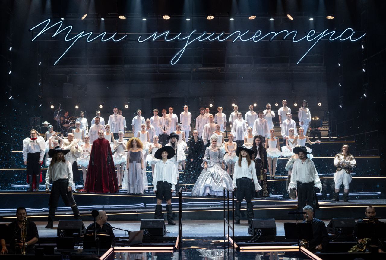 Спектакль Три мушкетёра 2026 в Театре Моссовета драматический концерт на стыке ностальгии и авангарда В Театре Моссовета представили яркую премьеру сезона Трёх мушкетёров Евгения Марчелли Это не просто спектакль а энергичный концерт в котором музыка Максима Дунаевского и стихи Юрия Ряшенцева становятся главными героями действия Режиссёр сосредоточился на ключевых музыкальных образах объединив их нитью условного сюжета Здесь классика встречается с эстетикой комикса а действие наполнено иронией от диалогов вздохами до эффектного слома четвёртой стены Актёрский ансамбль впечатляет драйвом мушкетёрская четвёрка вокально и хореографически едина словно современная поп группа Новое прочтение получили и сами герои от ранимого но отважного гасконца представленного Арсением Васильевых до величественной но тревожной королевы в исполнении Ольги Кабо О том как знакомая история обрела второе дыхание читайте в нашем обзоре teatrmossoveta Подпишитесь на afishams