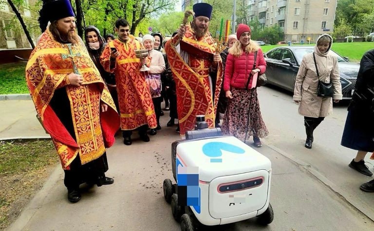 Священник Храма Благовещения Богородицы в Петровском парке окропил святой водой робота-доставщика, сообщает районное сообщество в ВК «Аэропорт и Сокол». Это произошло во время Крестного хода, подтвердили РБК в храме. «Попался в наши сети робот, «…» ехал, наверное, навстречу. Ладно, ехал бы вместе с нами, крестным ходом. А он попался навстречу. Ну что, тут батюшка проявил, видите, какую инициативу такую, которая всем понравилась» Еда внутри робота-доставщика считается освященной, а «от святой воды хуже никому не будет, даже роботу-доставщику», добавил представитель храма в комментарии «Подъёму». На роботе изображен логотип «Яндекс Лавки». Фото: Майа / aerosokol / VK Читать РБК в Telegram