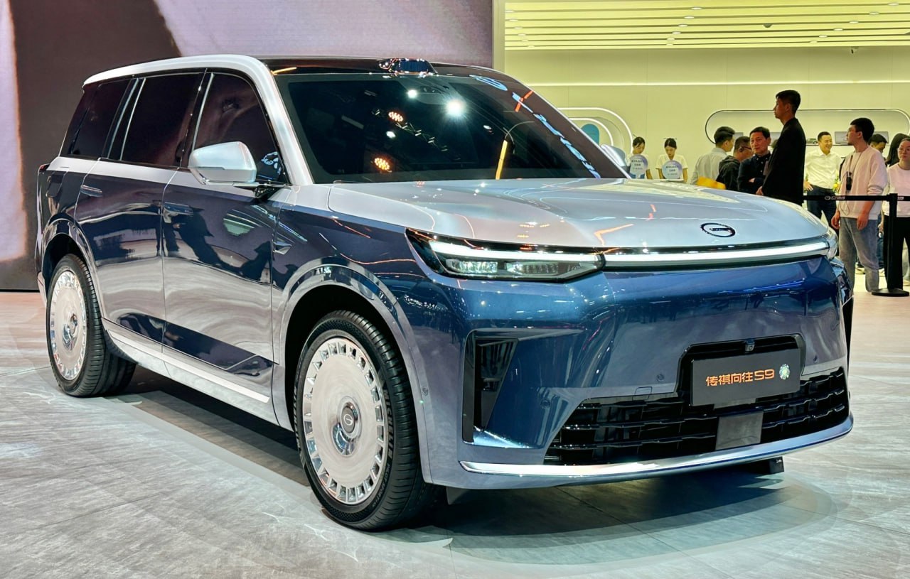 GAC представил роскошный кроссовер Trumpchi S9 В Шанхае показали флагманский кроссовер Trumpchi S9 — пятиметровый гибрид с премиальной отделкой и высокотехнологичной начинкой. Модель отличается сдержанным дизайном с узкой оптикой и скрытыми ручками, а коэффициент лобового сопротивления составляет 0,27. В салоне — два варианта компоновки: пятиместный и шестиместный с массажными креслами второго ряда. Мультимедиа работает на системе Huawei HarmonyOS Cockpit 5, в арсенале — три дисплея, включая 27-дюймовую проекцию. Силовая установка — последовательный гибрид с 1,5-литровым турбомотором 160 л.с. , 800-вольтовой системой и батареей CATL на 44,6 кВт⋅ч, обеспечивающей 252 км на электротяге и до 1400 км суммарного хода. Trumpchi S9 стал первым серийным автомобилем с автопилотом Huawei Qiankun ADS 4.0, способным вести машину как на трассе, так и в городе.