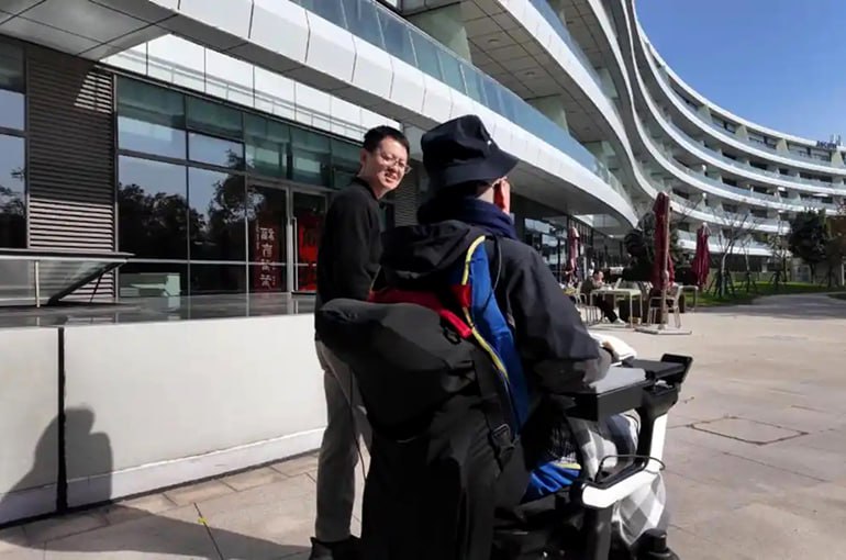 Парализованный ниже шеи устроился на работу он управляет роботами силой мысли Исследователи из Центра передового опыта в области науки о мозге и интеллектуальных технологий CEBSIT Китайской академии наук сообщили что пациент по фамилии Чжан получивший в 2022 году тяжёлую травму спинного мозга теперь контролирует умную инвалидную коляску роботизированных собак и цифровые устройства силой мысли Система WRS01 включает гибкие электроды вживлённые в мозг и процессорный чип установленный в черепе После нескольких недель тренировок пациент начал удалённую работу проверяя дистанционно с помощью курсора выдачу товаров из торговых автоматов Кроме того он может управлять коляской и отдавать команды робособакам для выполнения бытовых задач например чтобы принести еду Ключевым достижением стала скорость работы системы Задержка между сигналом мозга и действием робота составляет менее 100 миллисекунд что быстрее естественной передачи нервного сигнала в теле около 200 миллисекунд