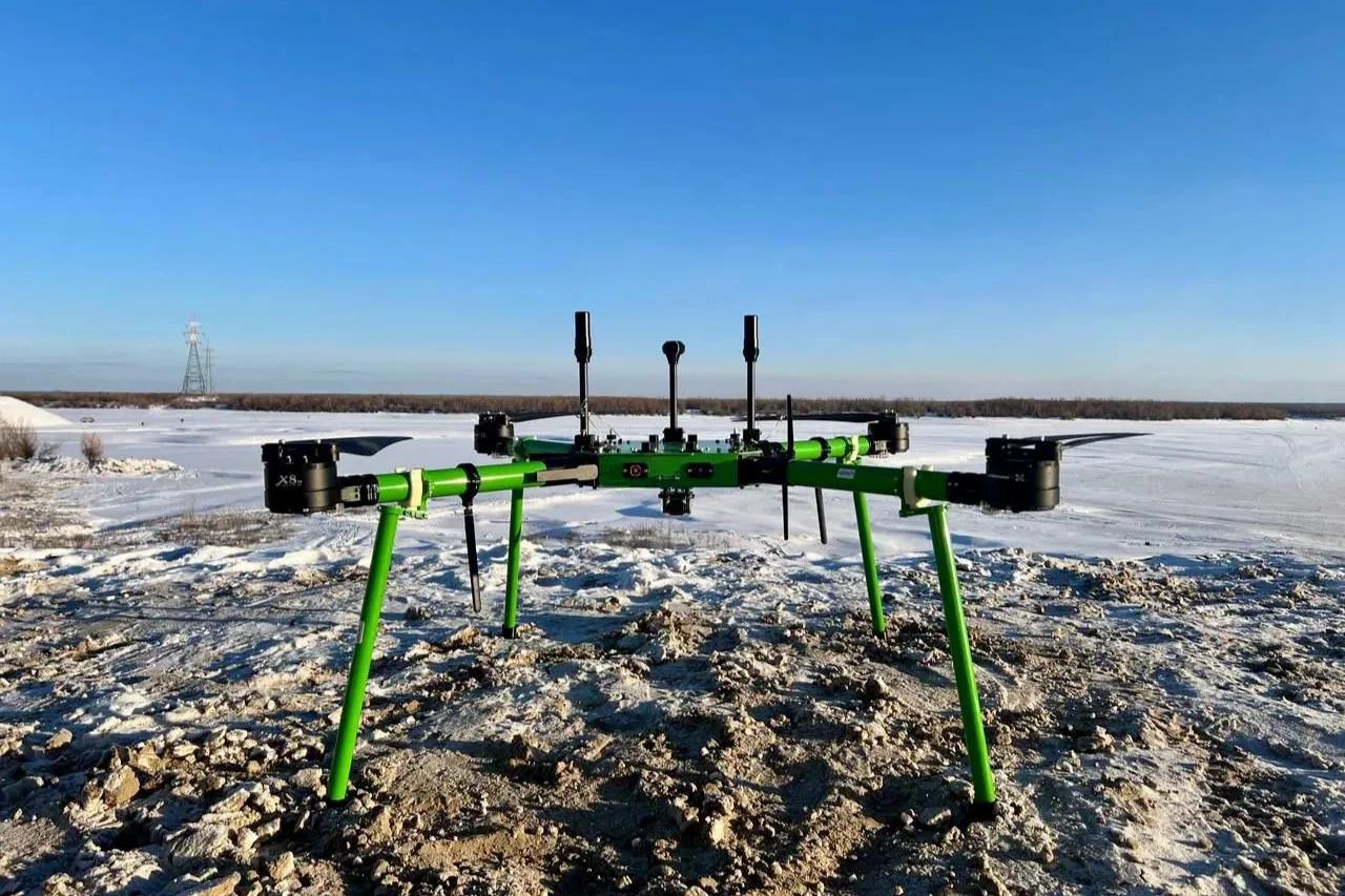 Дроны будут доставлять грузы в 30 градусный мороз в Якутии Воздушная переправа связывает Якутск и Нижний Бестях Первый этап проекта проходил с середины июля по 10 августа В этот период беспилотники перевезли порядка 600 килограммов грузов через реку Лена Операторы выполняли до десяти рейсов в день За один раз дрон может увезти до десяти килограммов груза Время рейса 15 минут Второй этап проекта пройдет в одно из самых сложных времен года во время ледостава и при 30 градусном морозе Использование дронов станет реальным решением для бесперебойной связи между населенными пунктами в межсезонье Это позволит сократить логистические издержки включая снижение времени доставки грузов в два три раза и уменьшение стоимости по сравнению с другими маршрутами сказал вице премьер РС Я Анатолий Семенов Фото правительство РС Я