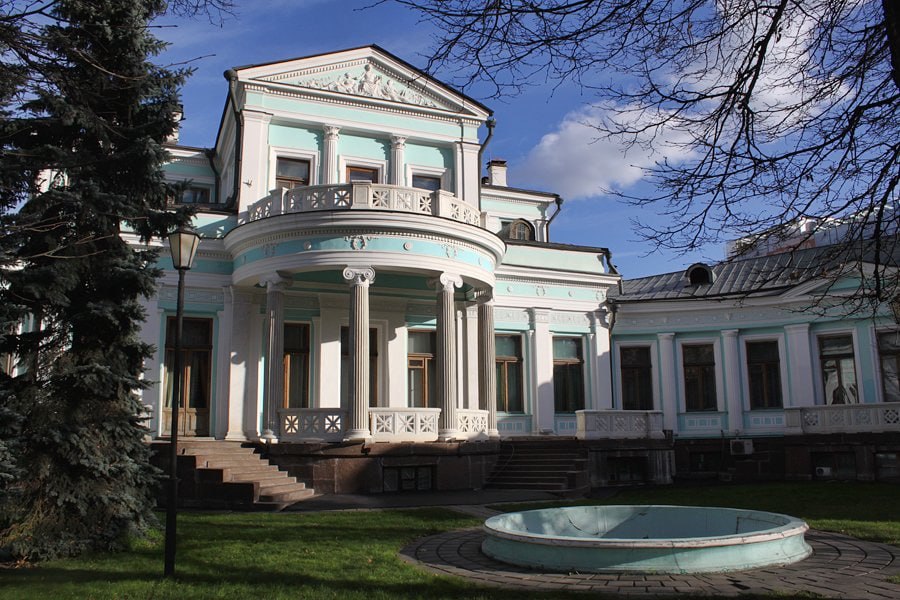 Особняк Морозовой на Смоленском бульваре В начале XIX века на этом участке стояла усадьба генералши Глазовой В 1879 году архитектор А И Резанов перестроил её для чаеторговца К С Попова стиль неогрек с элементами ампира и эклектики В 1894 году особняк приобрёл фабрикант Михаил Абрамович Морозов и поручил В А Мазырину перестройку интерьеров и фасадов Убранство стало ещё более экзотическим появились мавританские египетские помпейские охотничьи греческие русские залы а интерьер дополнил саркофаг с настоящей мумией и сфинксами После смерти Михаила дом унаследовала Маргарита Кирилловна Морозова Она превратила особняк в литературно интеллектуальный салон где собирались Скрябин Андрей Белый Собинов и другие деятели культуры В гостиной встречались светские беседы музыкальные вечера и даже спиритические сеансы В советские годы здесь разместили клуб Октябрьской революции райком партии а затем филиал Дома пионеров В конце СССР здание закрепили за Верховным Советом СССР затем за Управлением делами президента С 1993 по 2015 годы в особняке располагался банк Российский кредит а с 2017 года Российский институт стратегических исследований В 2017 2018 годах прошла масштабная реставрация фасадов по историческим чертежам Были восстановлены лепной декор головы львов греческие скульптуры мраморные детали балконные двери и окна Облик здания возвращён к состоянию конца XIX века фасады окрашены в бирюзовый тон отреставрированы колонны и портал входа