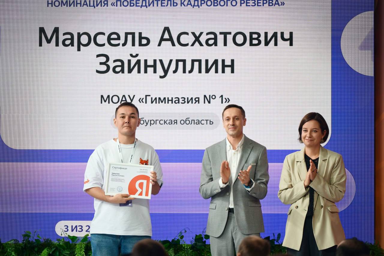 Учитель информатики из Оренбурга стал победителем премии «Яндекс Учебника» Учитель информатики гимназии № 1 г. Оренбурга Марсель Зайнуллин стал одним из победителей премии «Яндекс Учебника». Это ключевой конкурс программы «Кадровый резерв», направленной на поддержку профессионального развития преподавателей информатики, внедрение современных методов обучения и повышение качества ИТ-образования. Главным призом для победителя стала стажировка в московском офисе «Яндекса», где учитель совместно с другими победителями посетил лекции о применении ИИ в образовании и участвовал в разработке образовательных проектов вместе с методистами «Яндекс Учебника». Также Марсель Зайнуллин представил Оренбургскую область на II Всероссийской конференции «Яндекс Учебника», посвященной 40-летию преподавания информатики в школах. Онлайн-трансляцию конференции посмотрели более 60 тысяч учителей информатики. В 2024–2025 учебном году в программе «Кадровый резерв» приняли участие более 20 тыс. учителей России. Баллы участникам начислялись за внедрение современных образовательных технологий, повышение квалификации, разработку авторских учебных материалов, а также за обмен опытом с коллегами. По итогам года 1000 самых активных учителей боролись за премию «Яндекс Учебника» в трех номинациях.