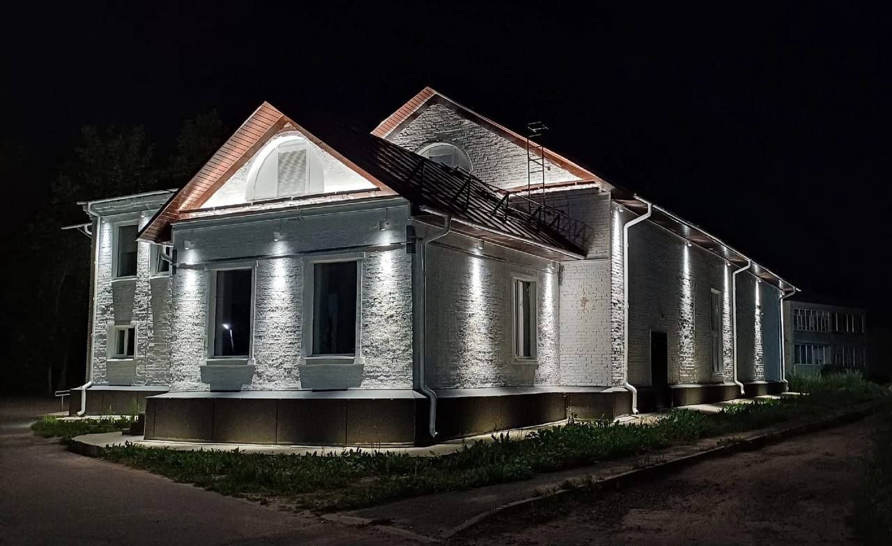 Тихменевский центр досуга украсила архитектурная подсветка. Новое освещение подчеркнет внешние особенности здания и сделает его визуально выразительнее в темное время суток. Кроме того, световое оборудование завершит тот комплекс работ, который был выполнен по нацпроекту «Культура». Теперь центр творческой жизни поселка будет еще и его ярким объектом.   Также в этом году световое оформление смонтировано на школе №49 в Ярославле, здании приемной комиссии ЯГТУ, стеле к 1000-летию Ярославля, мосте через Юхоть в Большесельском округе, здании администрации Гаврилов-Ямского округа. Работы запланированы еще более чем на 50 площадках. А всего с начала реализации программы архитектурной подсветки в нее вошли более 180 проектов.
