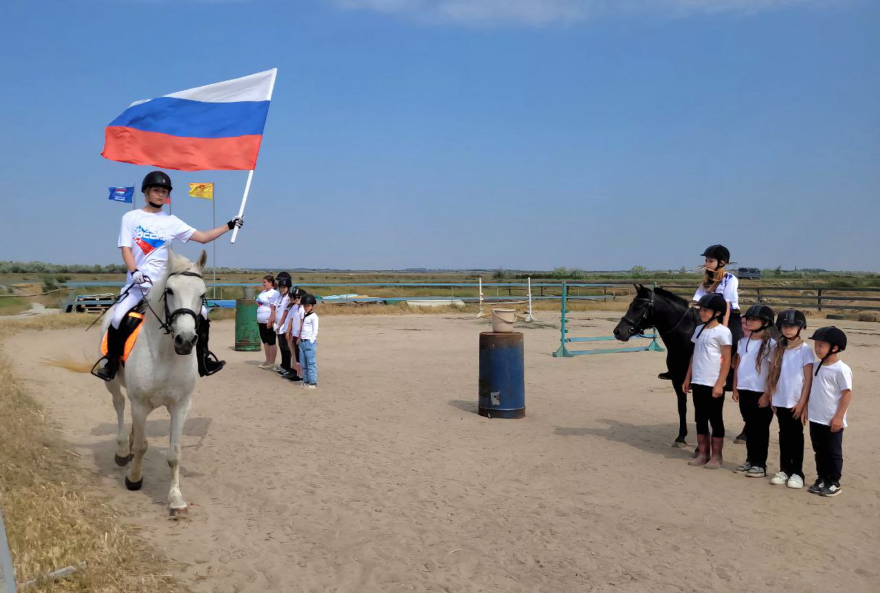 Эстафета ко Дню России прошла на конном клубе в Скадовске На базе конного клуба «Терсан» в Скадовске провели эстафету, посвященную Дню России. В празднике участвовали 30 детей: они возили воду верхом на лошади, прыгали в мешках на скорость и занимались хоббихорсингом . Помимо эстафеты, спортсмены из села Красное показали навыки жонглирования гирями, а учащиеся из Прокалиновки устроили состязания по армреслингу. Победу по сумме всех заданий одержала команда «Гаванна». Ребята получили дипломы за участие и вкусные подарки. Хоббихорсинг — вид спорта, в котором участники имитируют верховую езду на игрушечной лошади. Мероприятие состоялось благодаря Минспорту региона. Гостями стали представители казачества. ВКонтакте