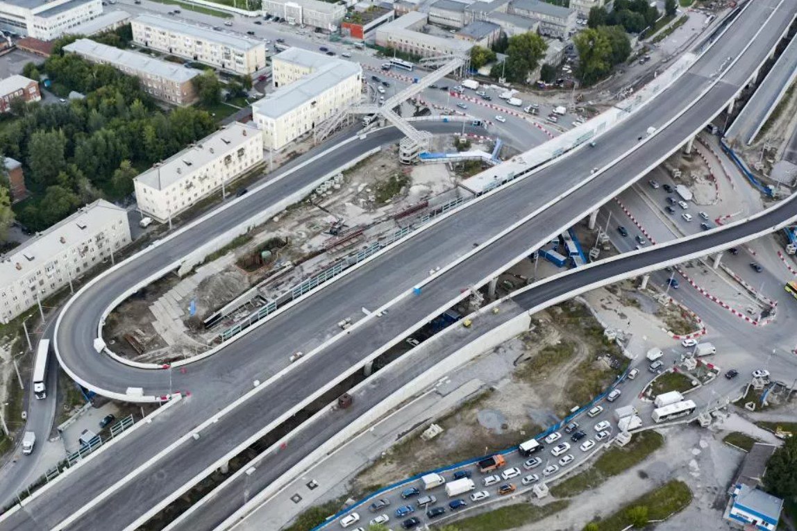 В Новосибирске откроют новые съезды на развязке четвертого моста 11 сентября на Центральном мосту Новосибирска запустят движение еще по двум съездам дорожной развязки на левом берегу в районе площади Труда В группе ВИС которая контролирует концессионера строительства переправы через Обь это событие анонсировали еще в прошлом месяце В инвестхолдинге сегодня подтвердили что уже завтра в 6 утра будет отрыто движение по съездам 7 и 24 После их ввода в эксплуатацию светофор у Димитровского моста уберут что значительно разгрузит автомобильный трафик на площади Энергетиков Кроме того новая схема обеспечит автомобилистам выезд с улицы Станционной и поворот на Димитровский мост