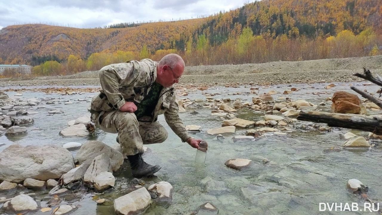 Общественники взяли пробы воды из замутившейся Силинки  Жители поселка Горный в Солнечном районе заподозрили сброс отходов добычи олова в реку Силинку. На их обращение Росприроднадзор ответил, что тяжелые металлы в воде не выявлены. Однако общественники решили проверить это самостоятельно, пишут «ДВНовости».  На место выехали экологический инспектор Михаил Тиняев и член Общественной палаты Светлана Федоренко. Они отобрали пробы воды в трёх точках реки, соблюдая все правила: указали координаты, зафиксировали время, температуру воды и воздуха, влажность и атмосферное давление.  При осмотре выяснилось, что в реку с хвостохранилища стекает мутный ручей. Вода в нём настолько грязная, что на камнях и берегах образовался серый налёт. По словам местных активистов, это могут быть осевшие отходы оловодобычи после летних утечек из пульпопровода. В момент их осмотра рядом работал экскаватор, который насыпал щебень вдоль ручья. Оператор техники заявил, что облагораживает местность, но при появлении активистов прекратил работы.  Неподалеку обнаружилась еще одна аномалия — из сопки сочится жидкость с радужными разводами на скалах. Горный инженер Сергей Картавый объяснил, что это могут быть последствия давней добычи полезных ископаемых, которые не обязательно связаны с текущей деятельностью местной фабрики.  — Этот ручей отводит воду от хвостохранилища, где остаются не полностью извлеченные элементы, такие как касситерит, медь и, возможно, свинец. Эти вещества могут вымываться из старого хвостохранилища, которое не имело гидроизоляции, — пояснил Картавый.  Вода в Силинке, по данным общественников, была частично мутной в месте, где впадал «облагораживаемый» ручей. Однако в десяти километрах ниже по течению река стала полностью непрозрачной. Проблема может быть связана не только с одной промышленной площадкой, но и с объектами, расположенными между поселками Горный и Холдоми. Амурская бассейновая природоохранная прокуратура взяла ситуацию с загрязнением под контроль.