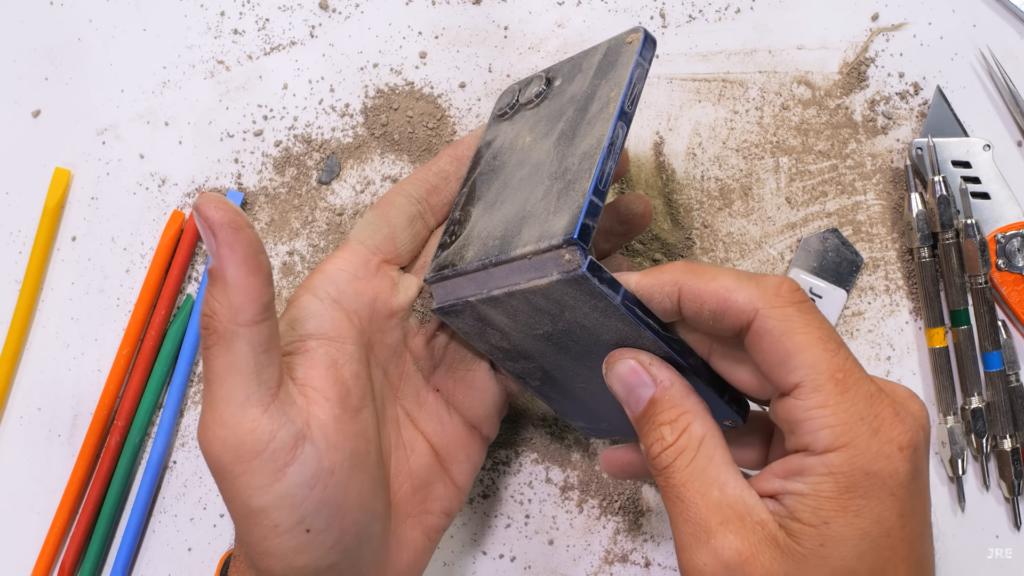 Блогер жёстко поиздевался над Galaxy Z Flip7. Шарнир выстоял отлично, но экрану повезло меньше  Популярный YouTube-блогер Зак Нельсон с канала JerryRigEverithing провёл свой фирменный тест на прочность на новой раскладушке Samsung Galaxy Z Flip7. Результат немного удивил.  Во время своих экспериментов Нельсон подверг Z Flip7 ряду испытаний, начиная с проверки на устойчивость к царапинам. На дисплее, защищённом стеклом Gorilla Glass Victus 2, появились видимые царапины при использовании инструмента с твёрдостью 6 по шкале Мооса. Этот результат соответствует большинству современных смартфонов. В целом, девайс не поцарапается от контакта с монетами или гвоздями. Даже защитная пленка объектива камеры выдержала попытки поцарапать его острыми предметами.  Однако, как и у предыдущих поколений, основной дисплей Z Flip 7 легко царапается ногтями. Глубокие следы остаются уже при уровне твёрдости 2 по шкале Мооса. Похоже, ультратонкое стекло  UTG  нового поколения с увеличенной на 50% толщиной, используется только в Z Fold7. Зато шарнир оказался исключительно мощным. В тесте на изгиб раскладушка не треснула и не потеряла функциональность. Шарнир также прошёл испытание на пыленепроницаемость, продолжая работать плавно даже после попадания мелких частиц.  Какой вывод? Несмотря на то, что Samsung добилась серьёзного прогресса в повышении прочности, особенно в области шарнира, внутренний дисплей остаётся уязвимым местом. Кстати, на днях у нас выходил обзор Galaxy Z Flip7 со всеми плюсами и минусами — обязательно чекните его.